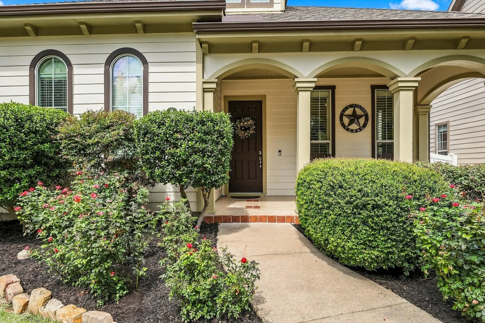 A shaded front porch offers a welcoming spot to greet guests or enjoy a quiet moment outdoors.