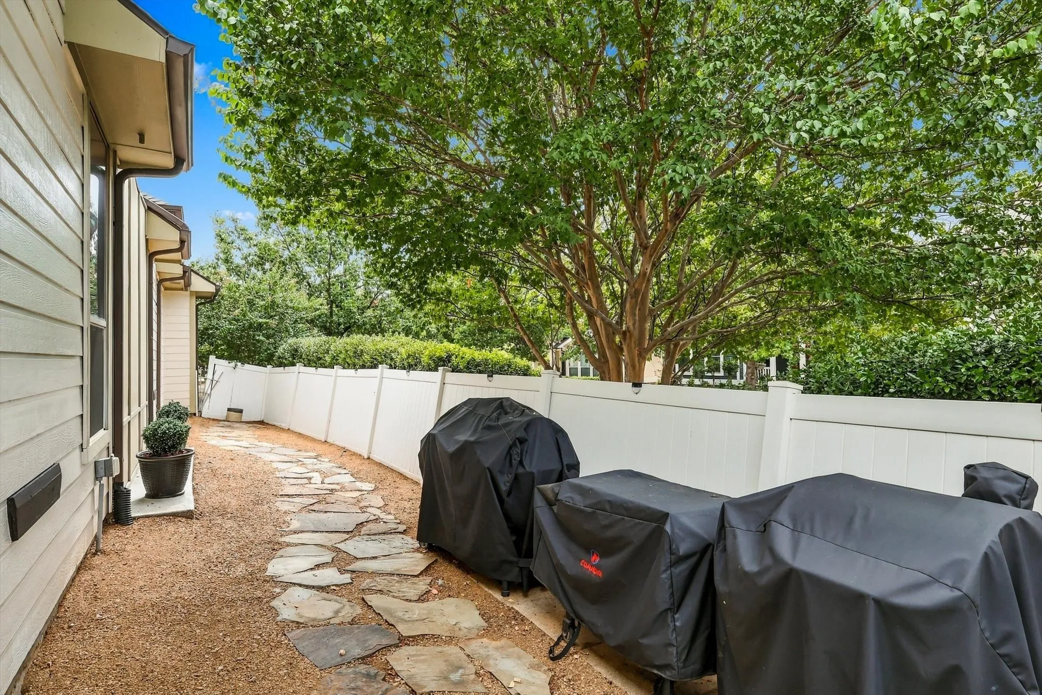 A flagstone footpath winds through the crushed-granite yard, connecting outdoor spaces and the grilling area.