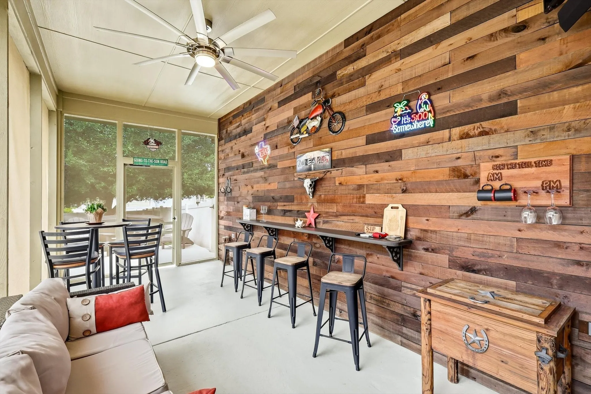 Bring friends together on the screened back patio, where a wood accent wall and bar seating create a relaxed gathering space.