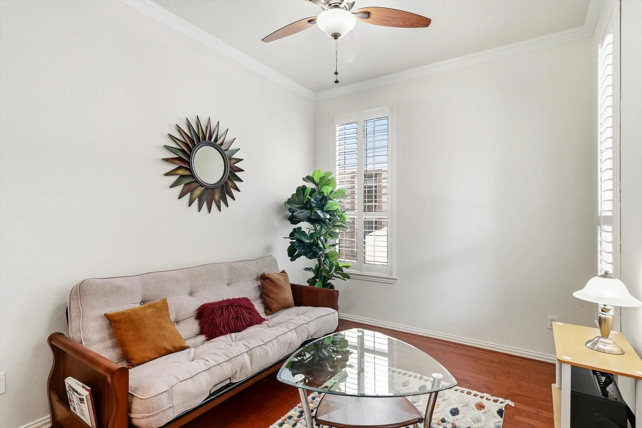 Plantation shutters and warm wood flooring bring character to this versatile front room.