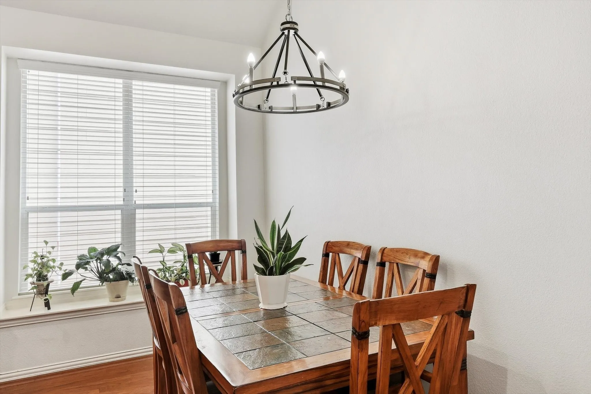 Gather for everyday meals in a sunny dining area accented by a distinctive chandelier.