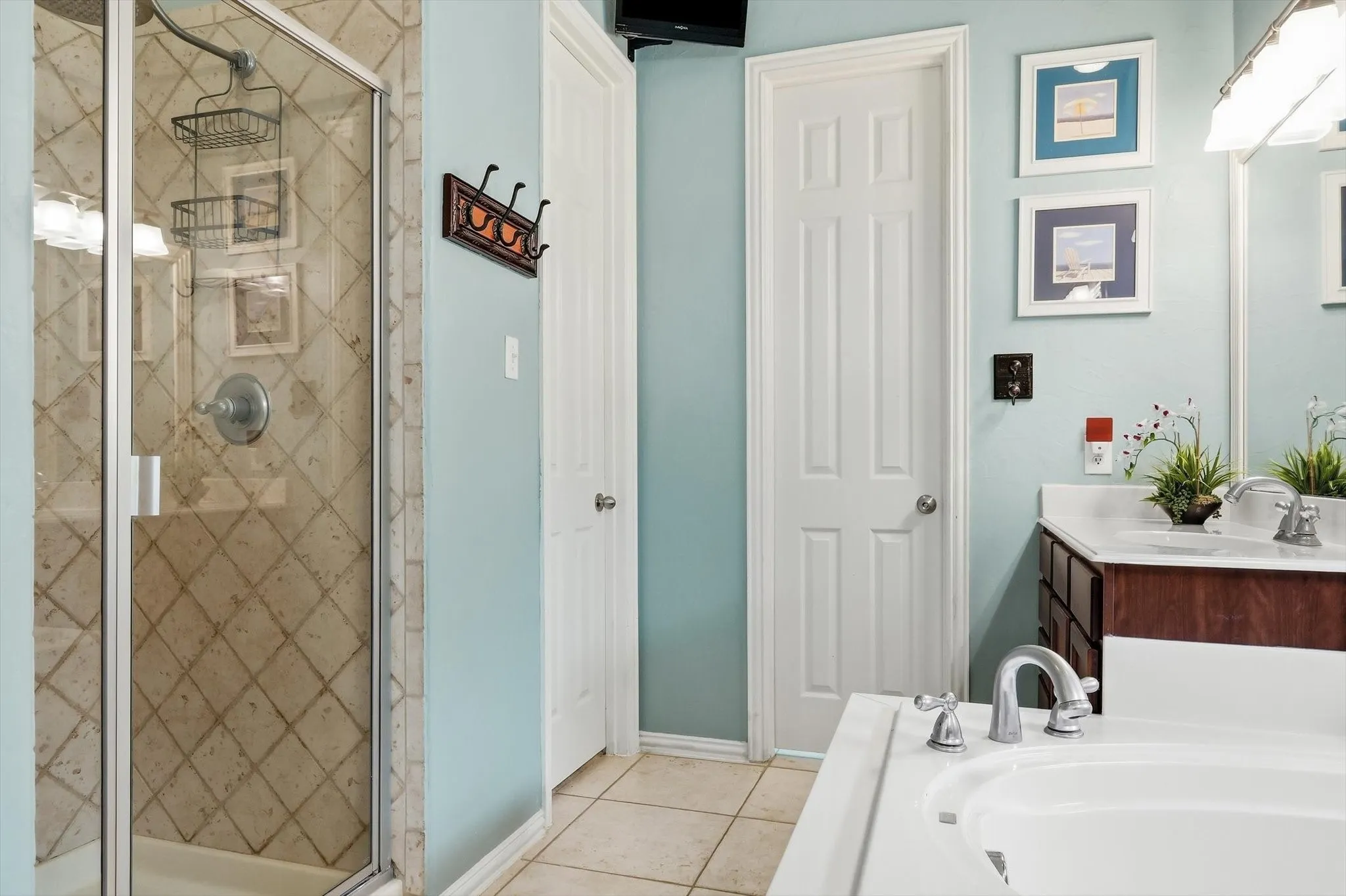 A separate tiled shower complements the soaking tub in the spacious primary bathroom.