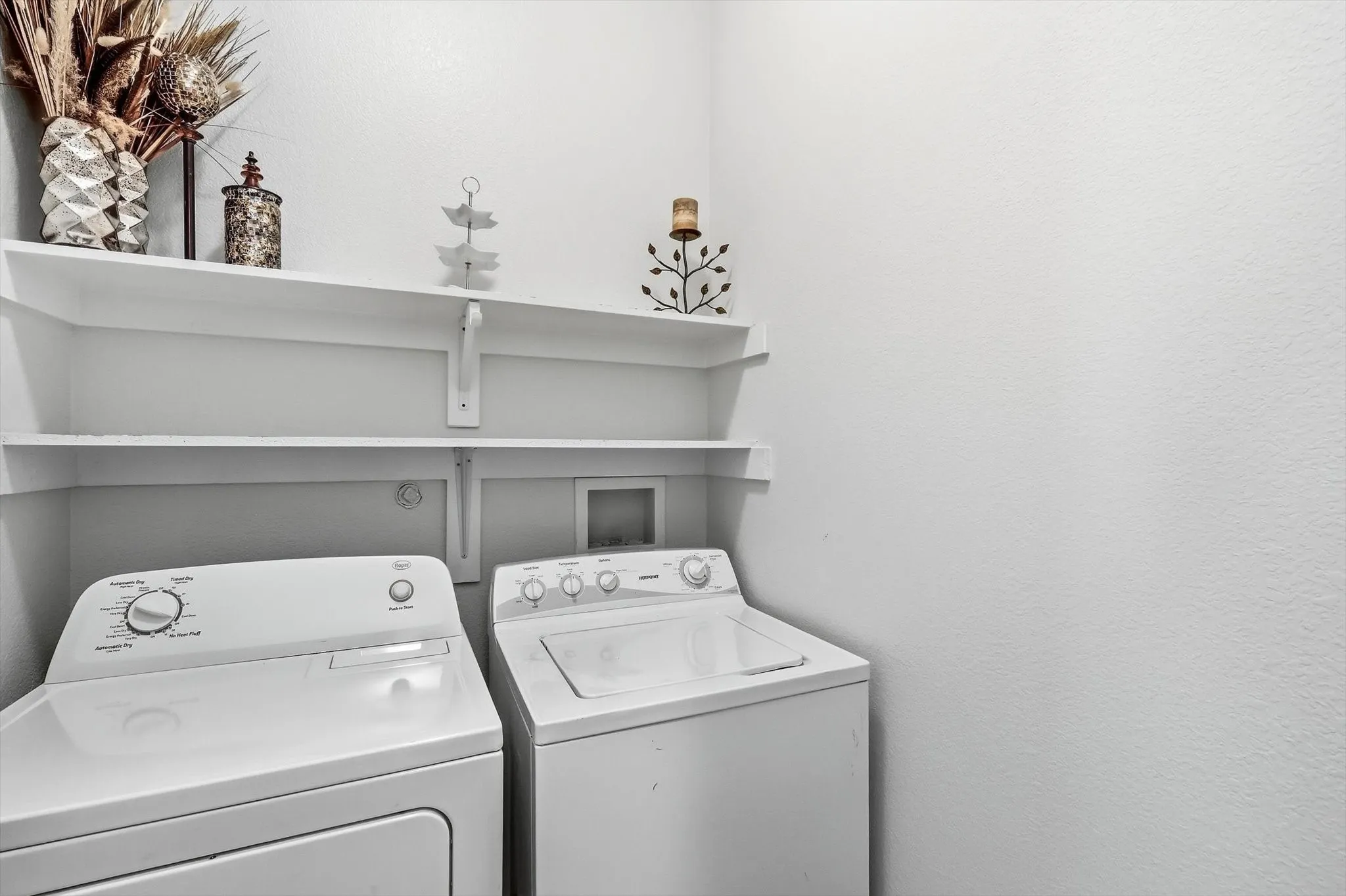 A dedicated laundry room with overhead shelving helps keep everyday essentials organized.