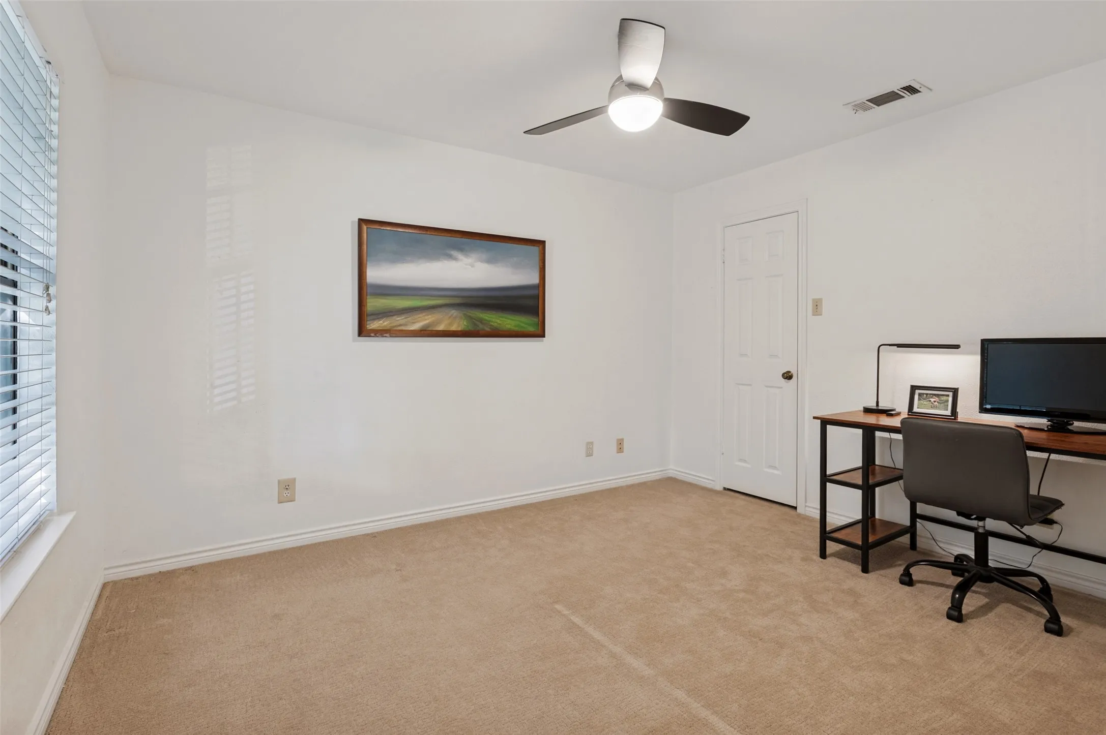 Neutral wall paint, carpet flooring, a ceiling fan with integrated lighting, and a window with blinds