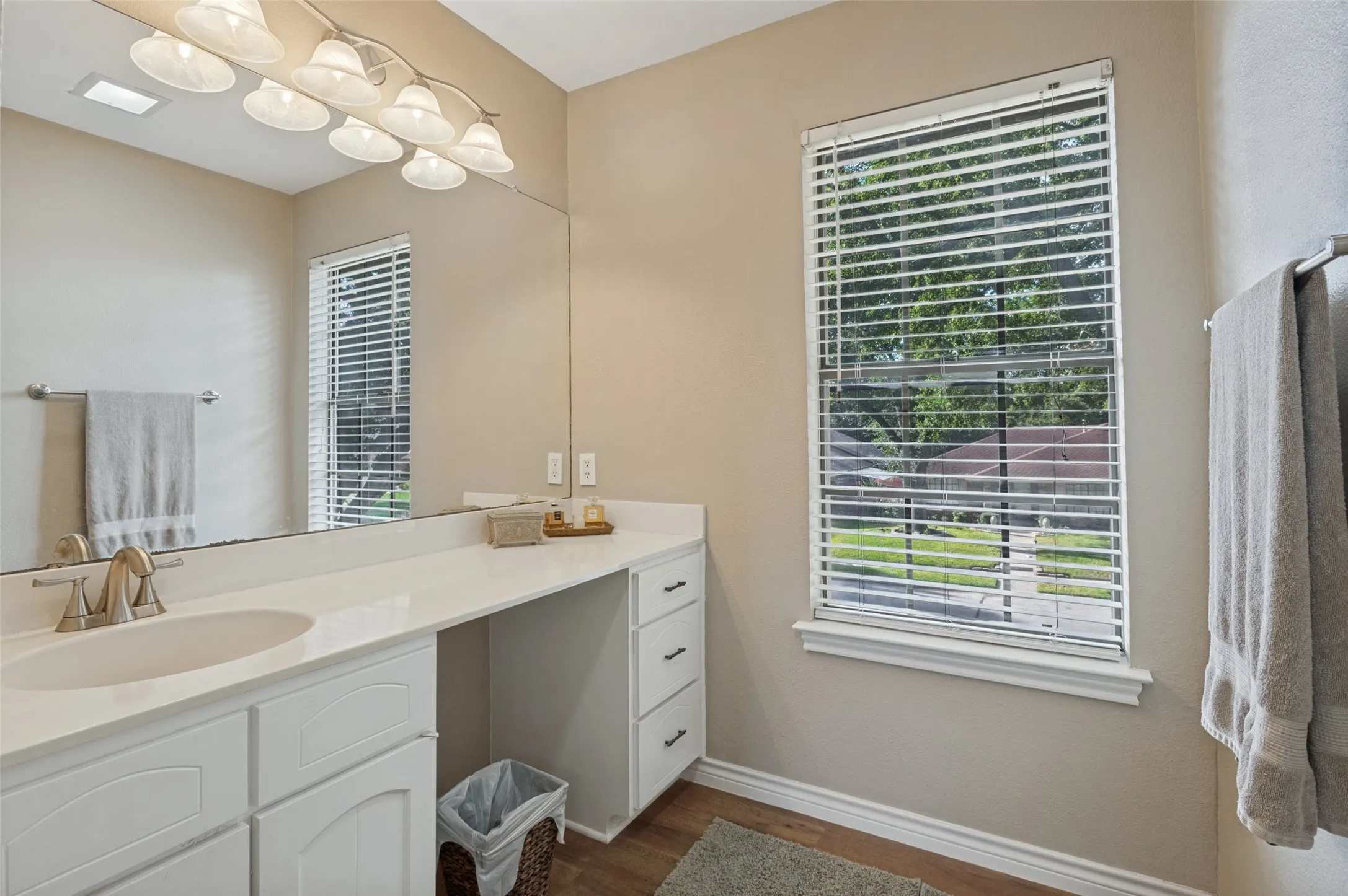 Spacious vanity with an integrated sink, expansive mirror, and dedicated makeup area