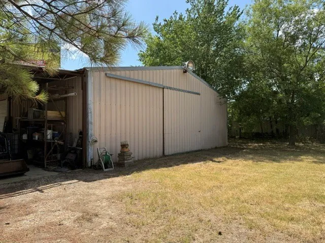 Metal-sided utility building with a sliding door and exterior lighting