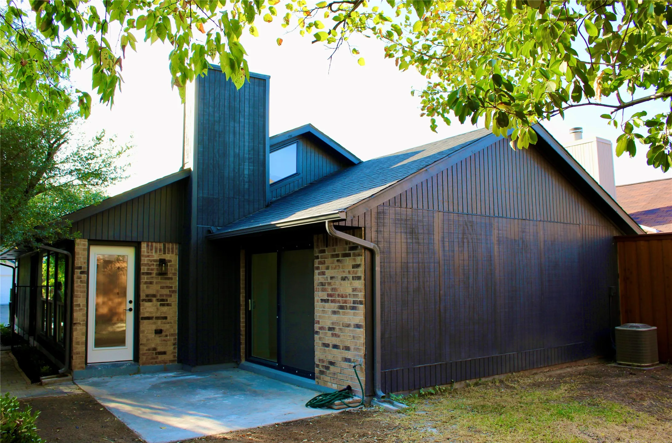 Contemporary exterior featuring vertical siding and brick accents