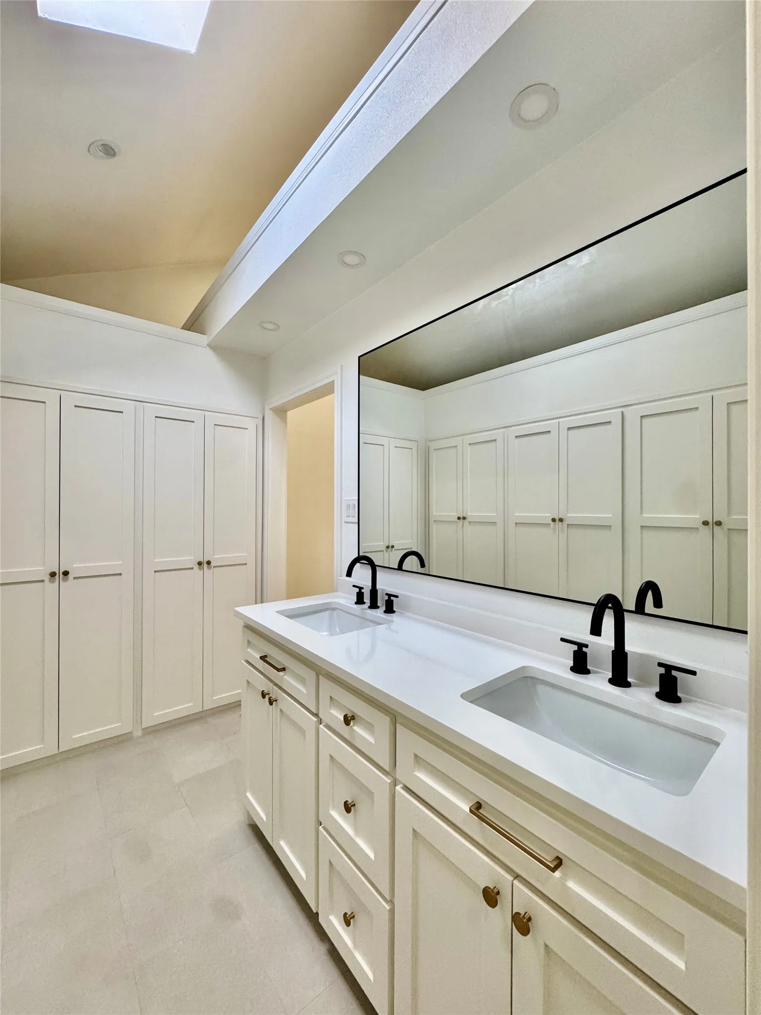 Dual vanity with integrated sinks, white countertops, and matte black fixtures