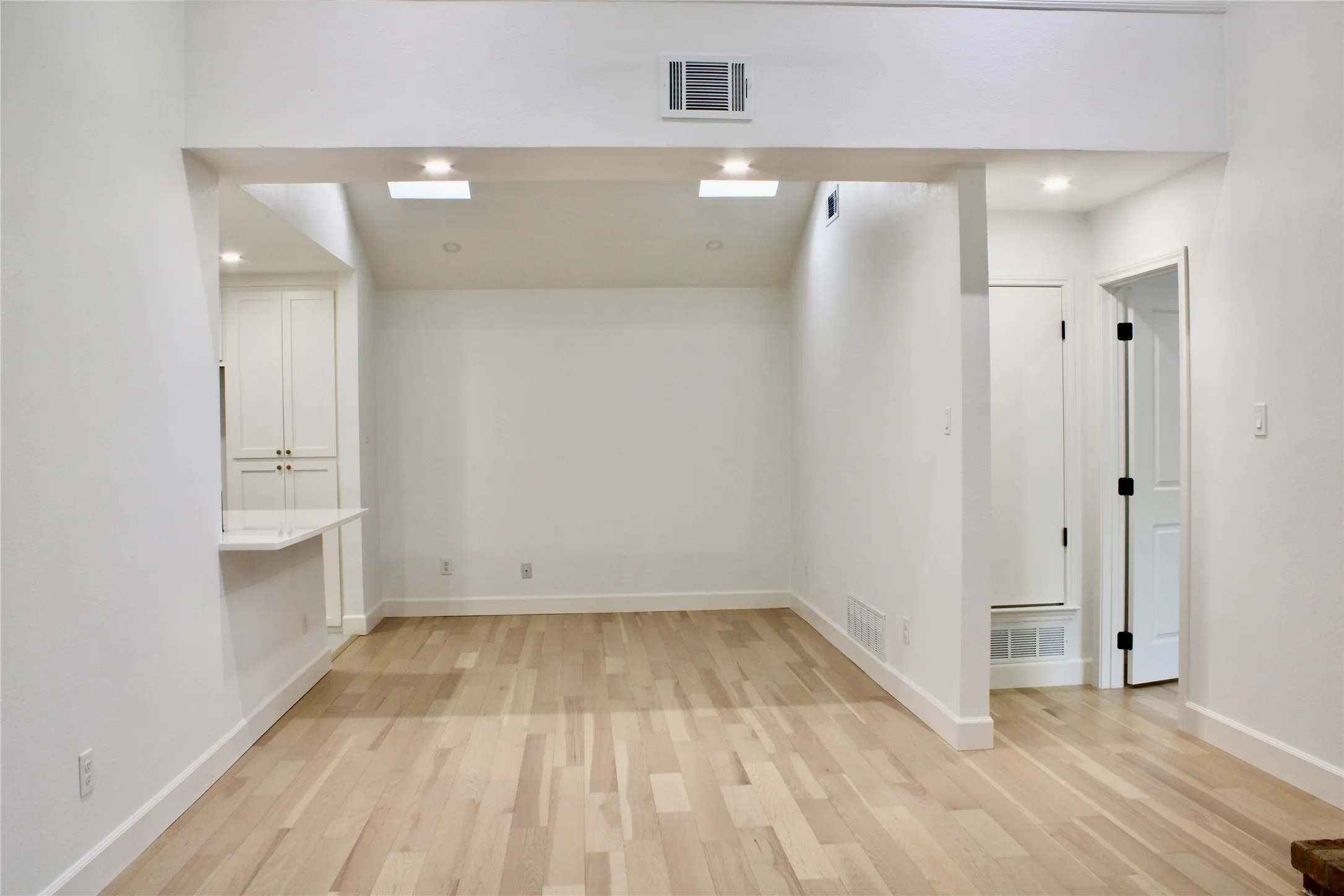 Wood-finish flooring, recessed lighting, and skylights enhance the space