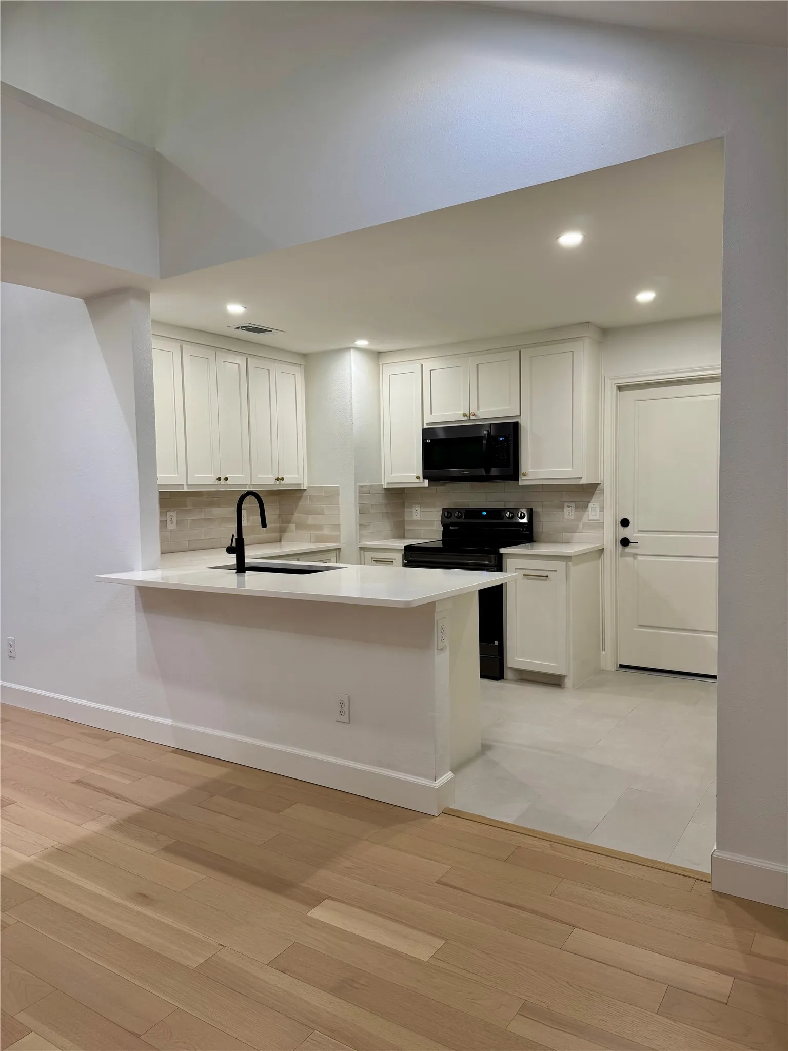 Modern kitchen with shaker-style cabinetry, quartz countertops, and a subway tile backsplash