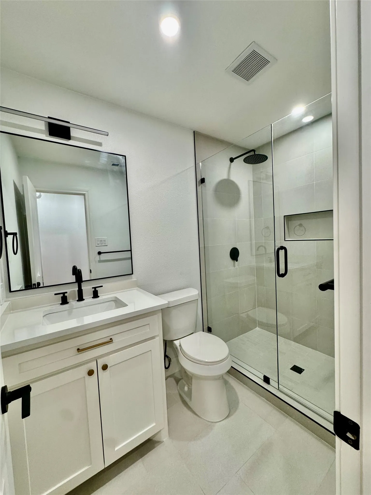 White vanity with gold-tone hardware, rectangular undermount sink, and matte black faucet