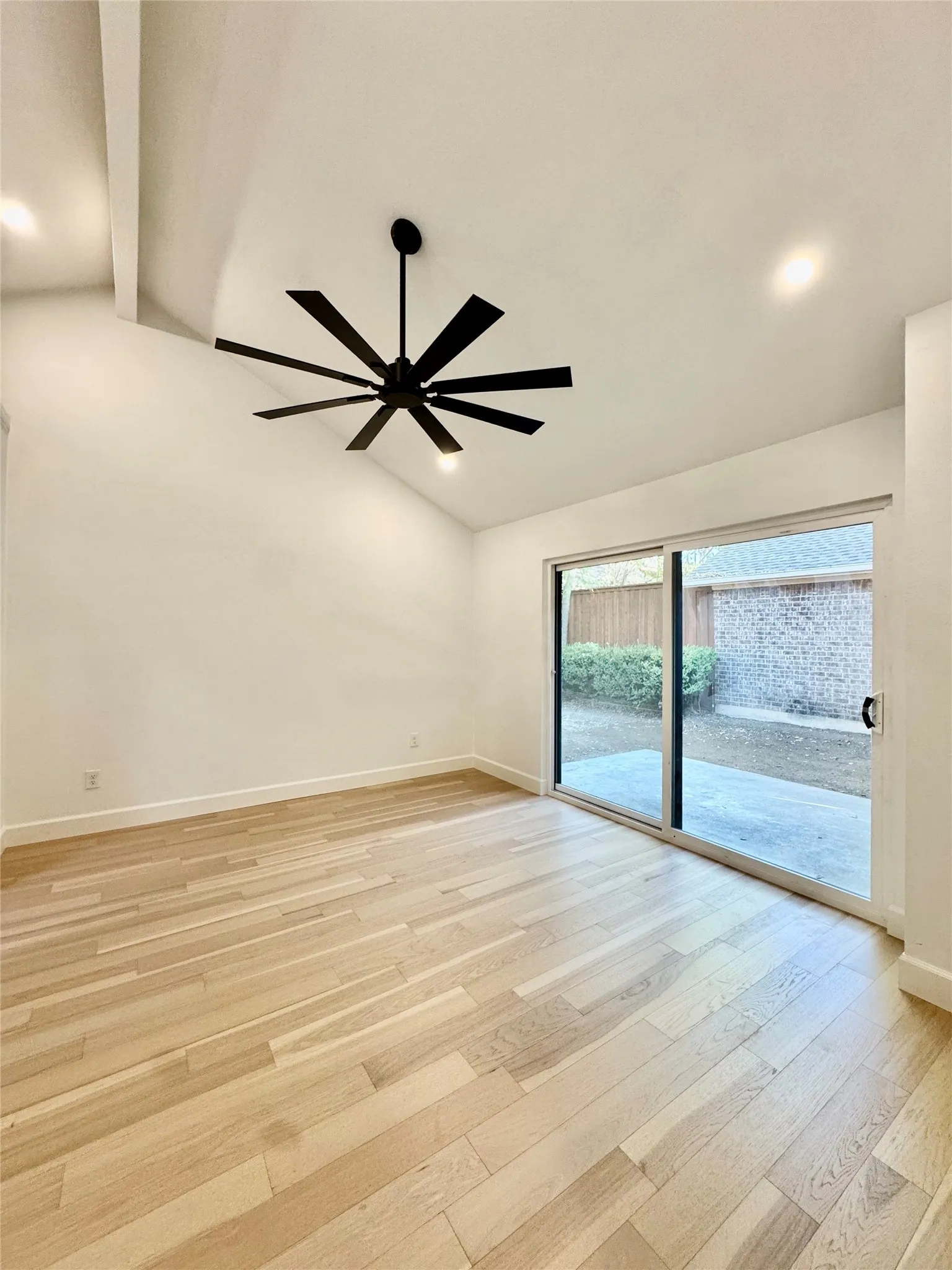 Vaulted ceiling with exposed beam, recessed lighting, wood-finish flooring, and a multi-blade ceiling fan