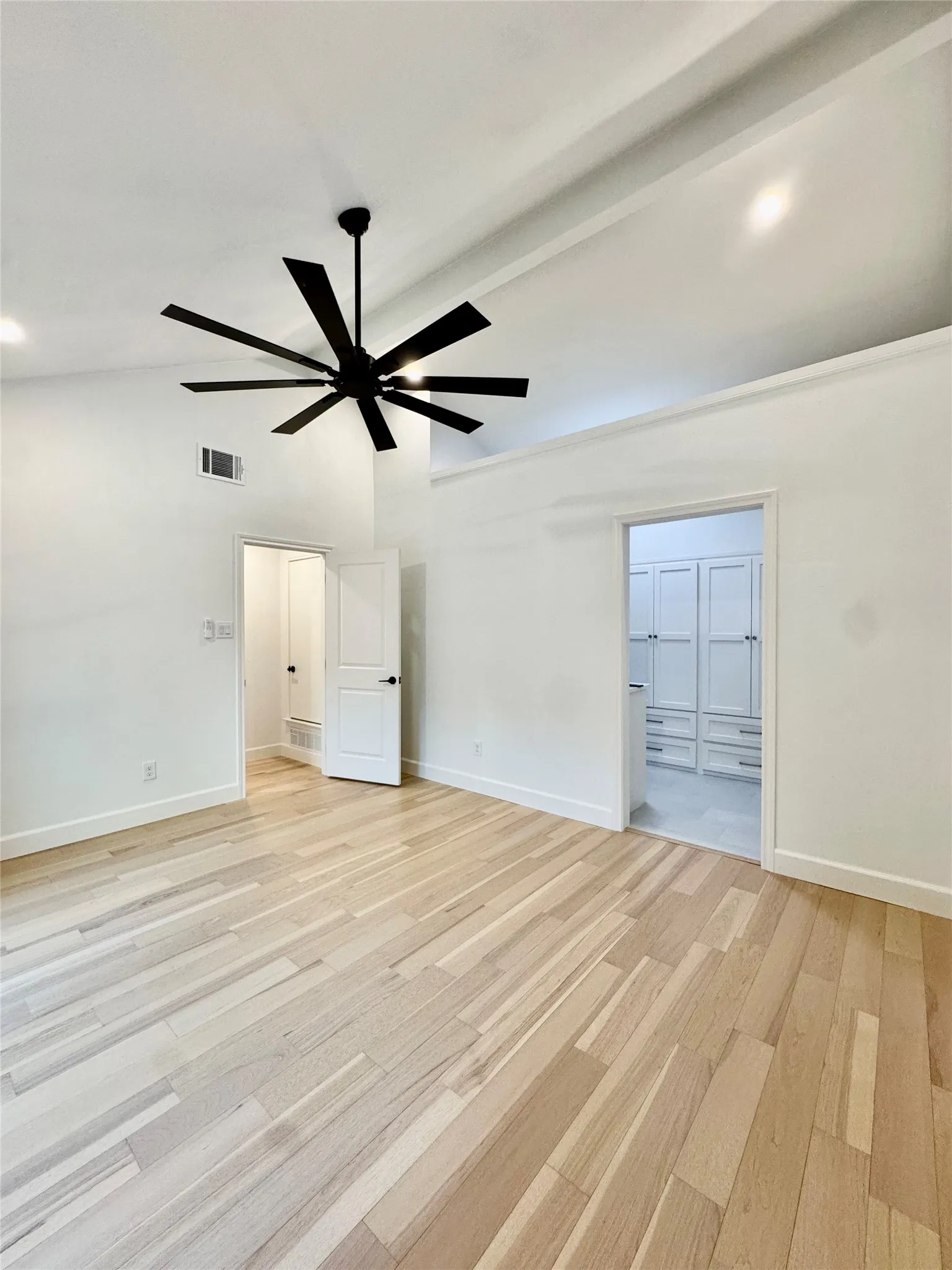 Recessed lighting, wood-finish flooring, vaulted ceiling, and built-in closet cabinetry