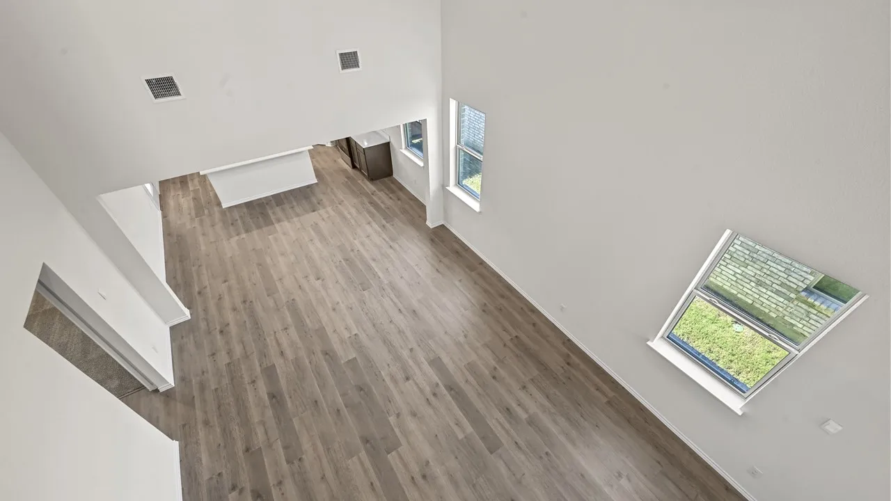 Vaulted ceiling with skylight, wood-finish flooring, white walls, and recessed lighting