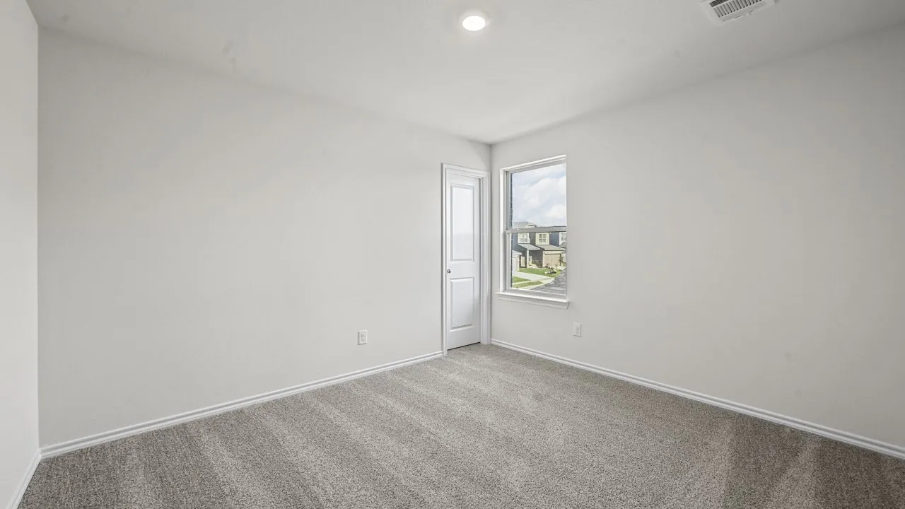 Recessed ceiling light, neutral wall color, window with exterior elements, carpeted flooring, and a white door