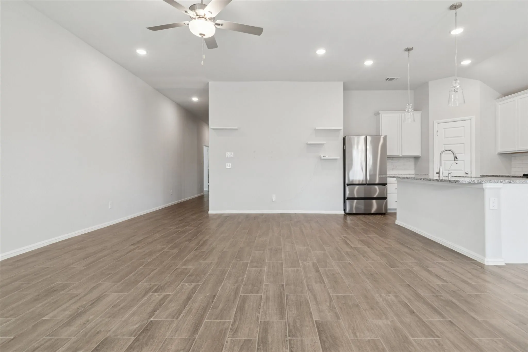 Wood-finish flooring throughout, recessed lighting, and a ceiling fan