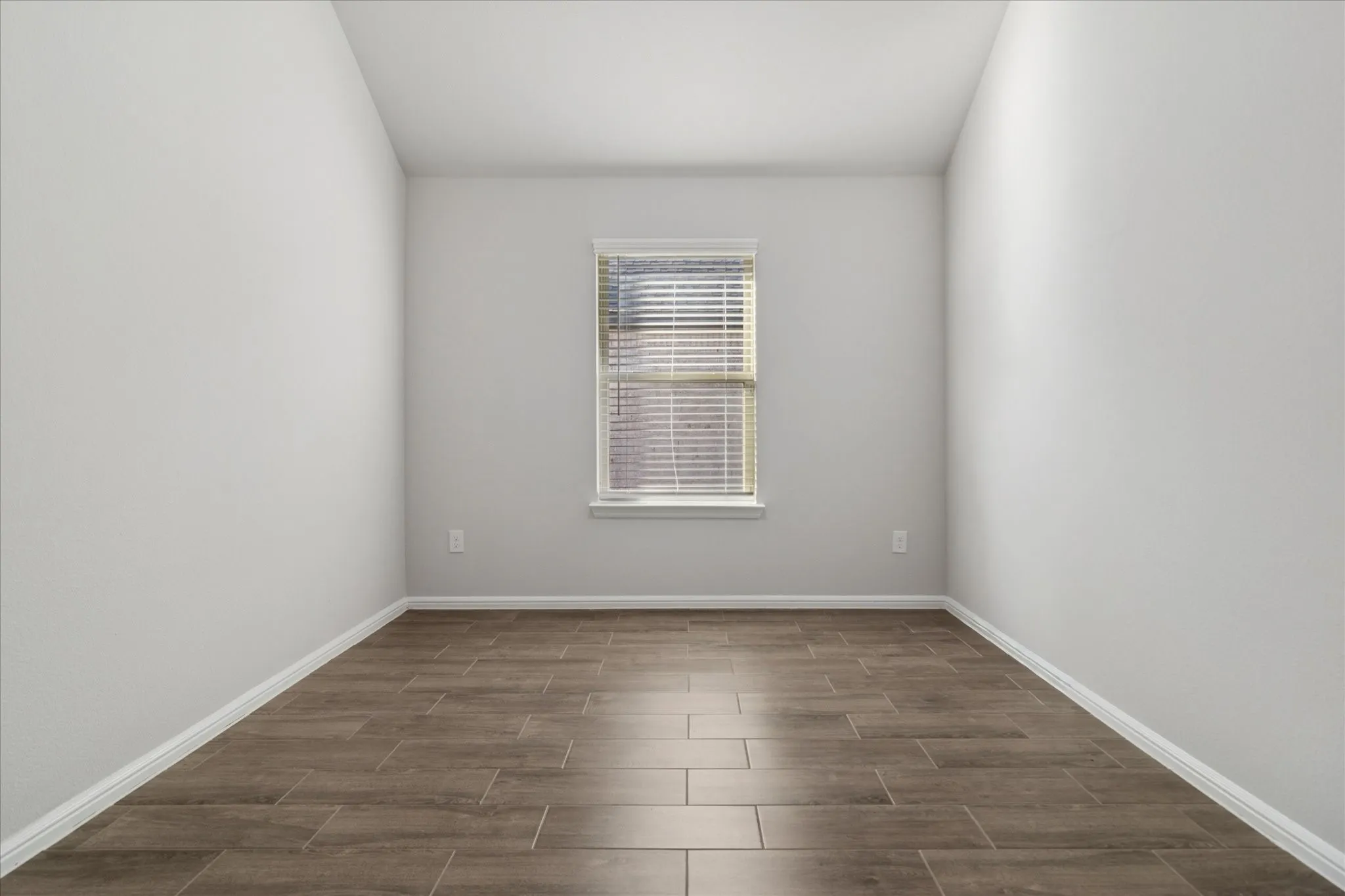 Wood-finish tile flooring, neutral wall tones, window with horizontal blinds, and white trim throughout