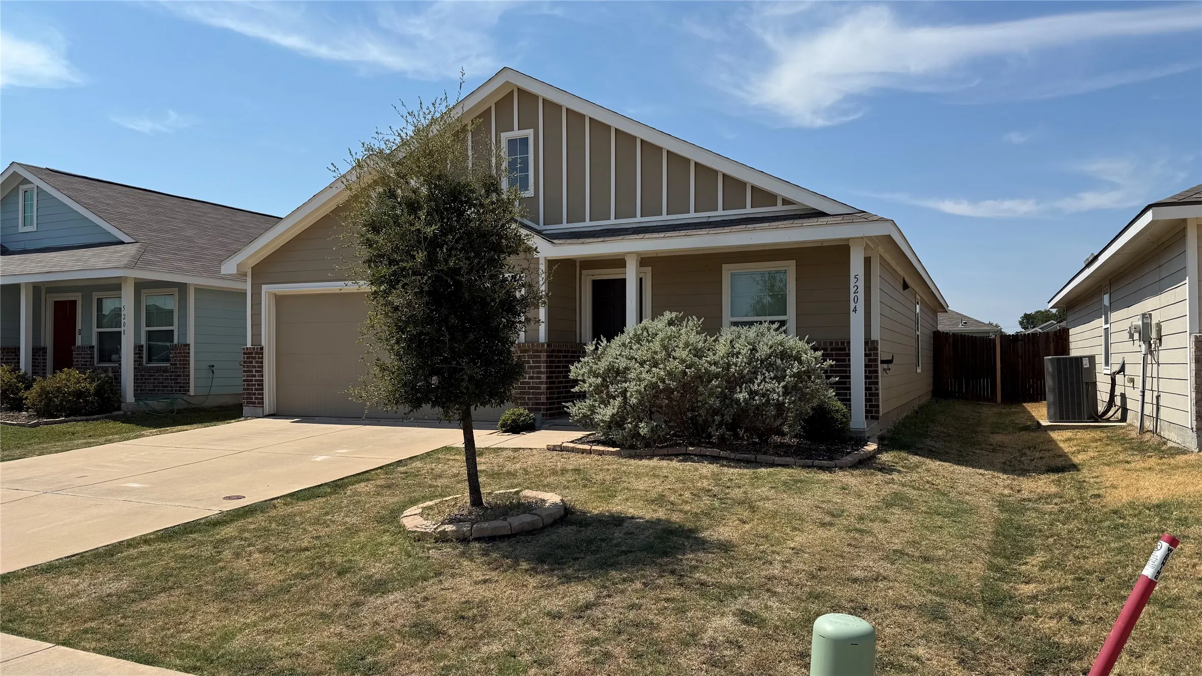 Single-story residence featuring a two-car garage, brick and siding exterior, and a privacy fence
