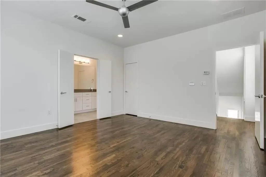Wood-finish flooring, recessed lighting, modern ceiling fan, white walls, and double doors