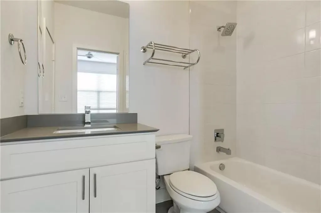 White vanity with integrated sink, sleek countertop, and chrome faucet