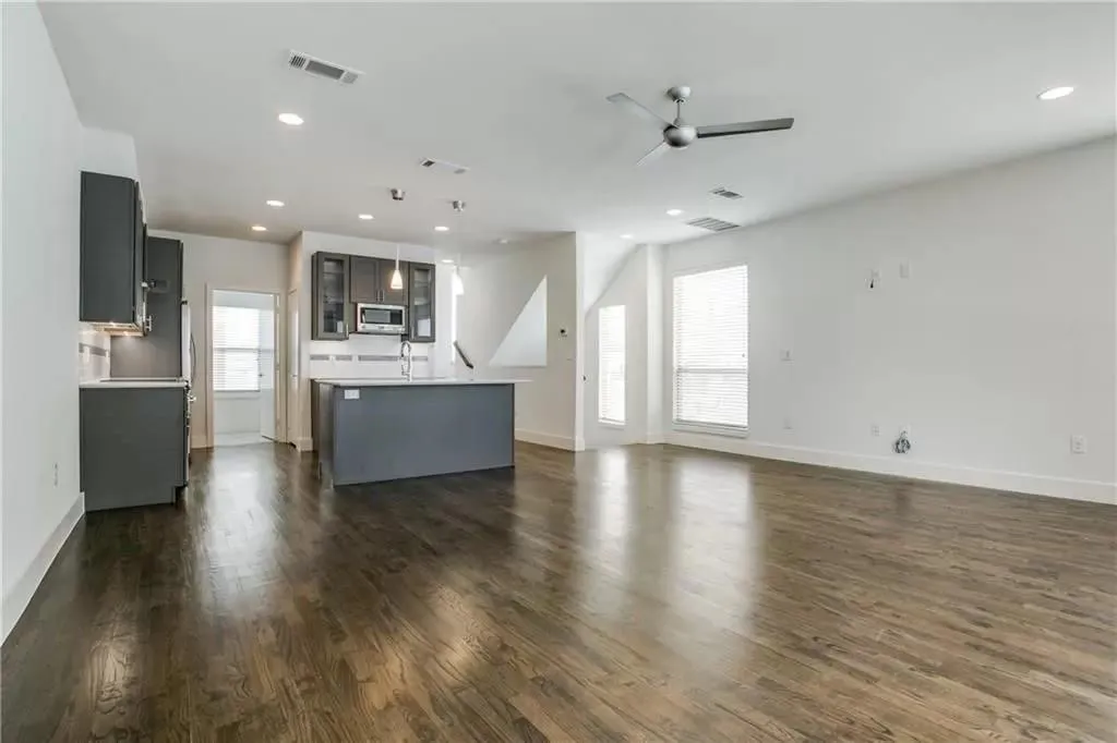 Open-concept living area featuring wood-finish flooring, recessed lighting, and a contemporary ceiling fan
