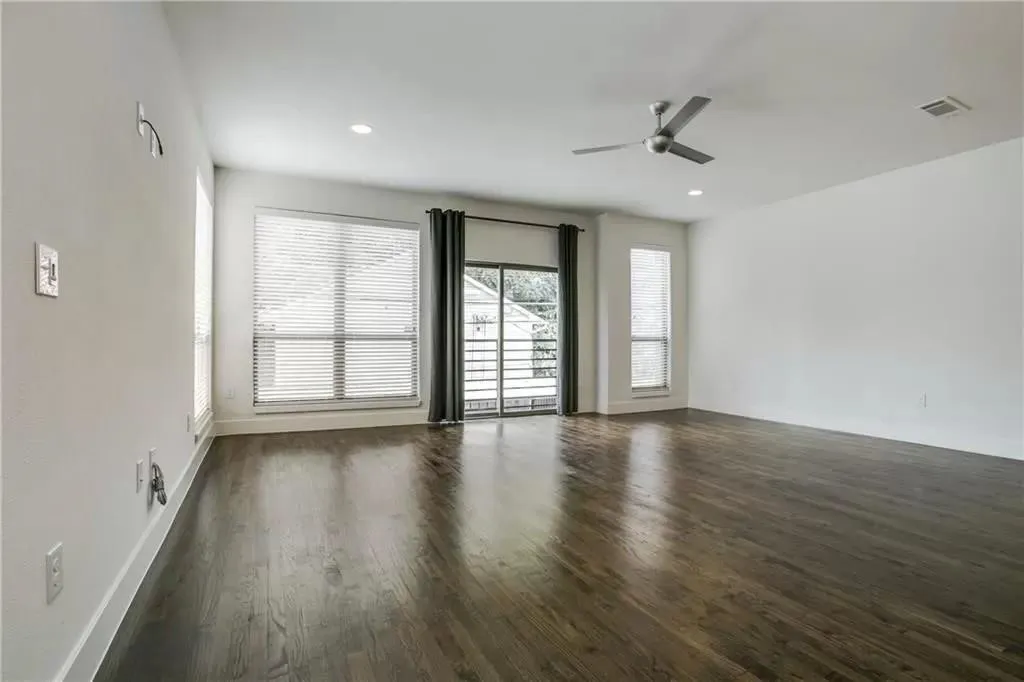 Expansive room featuring dark wood-finish flooring, recessed lighting, and a ceiling fan