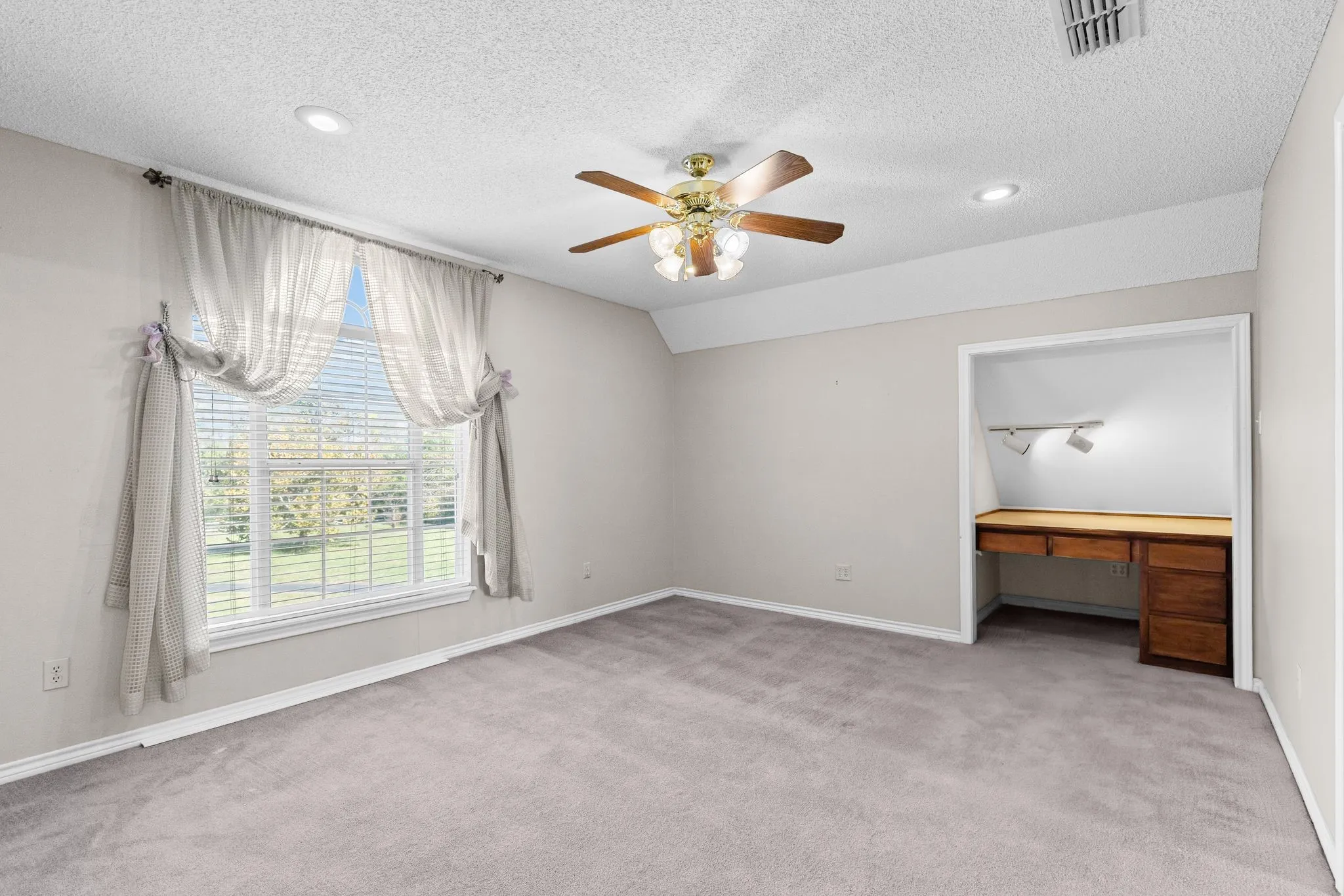 Bedroom 2 is one of the two bedrooms tucked behind the game room; has built-in desk with lighting.