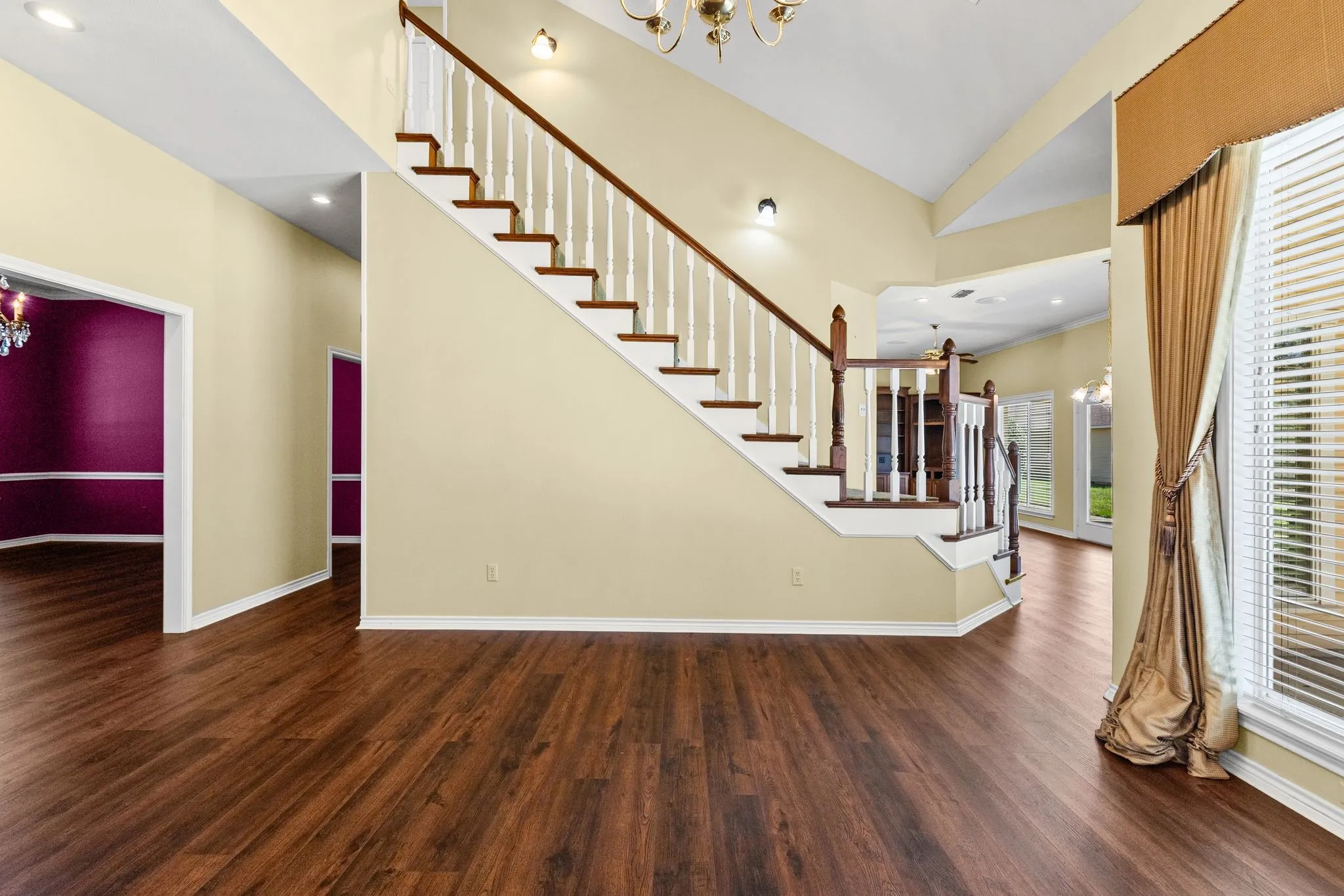 Living room has very high ceilings, gorgeous window treatments, overlooks the back yard.