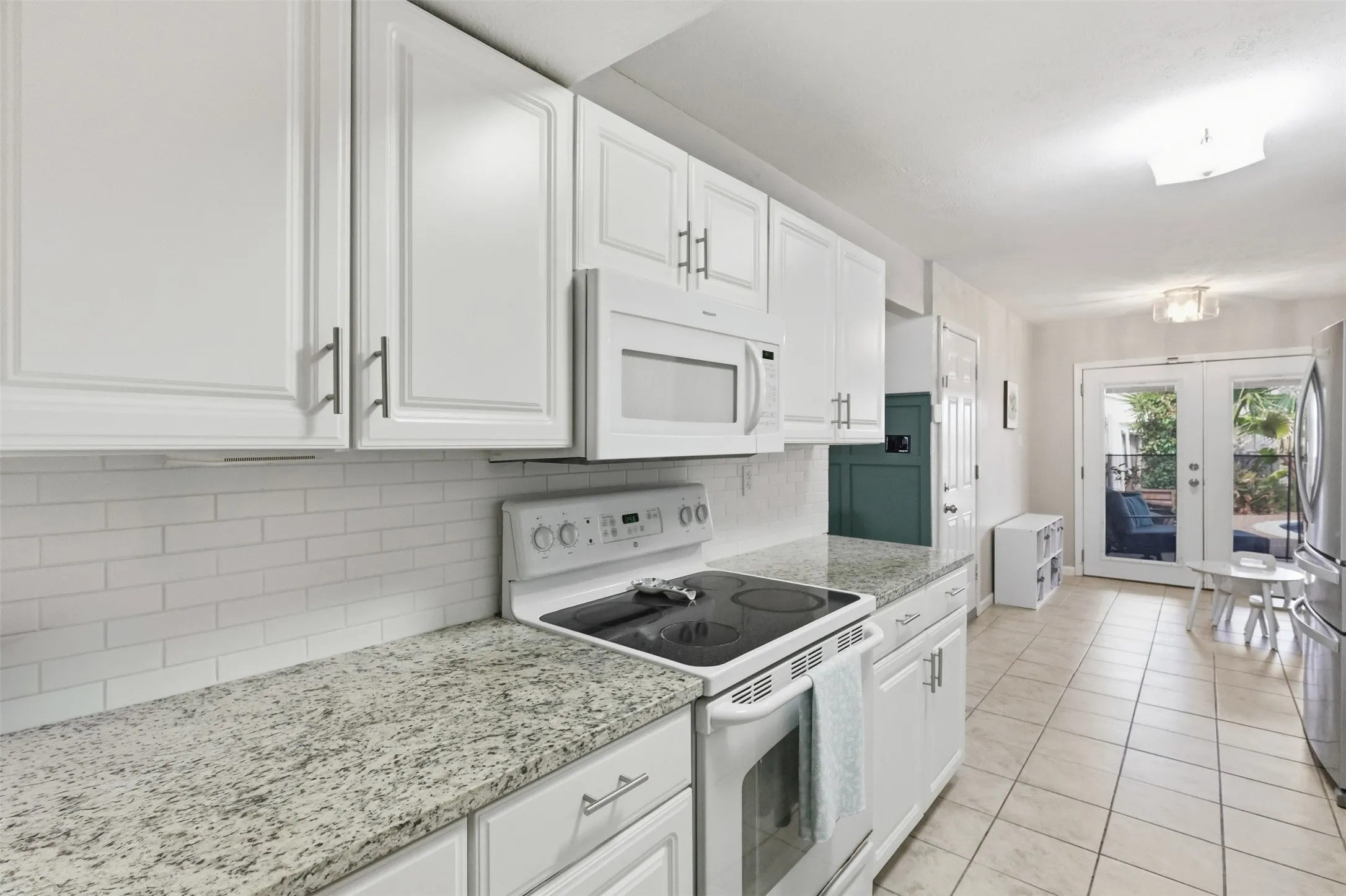 Another view of the kitchen highlighting the storage, workspace, and open feel.