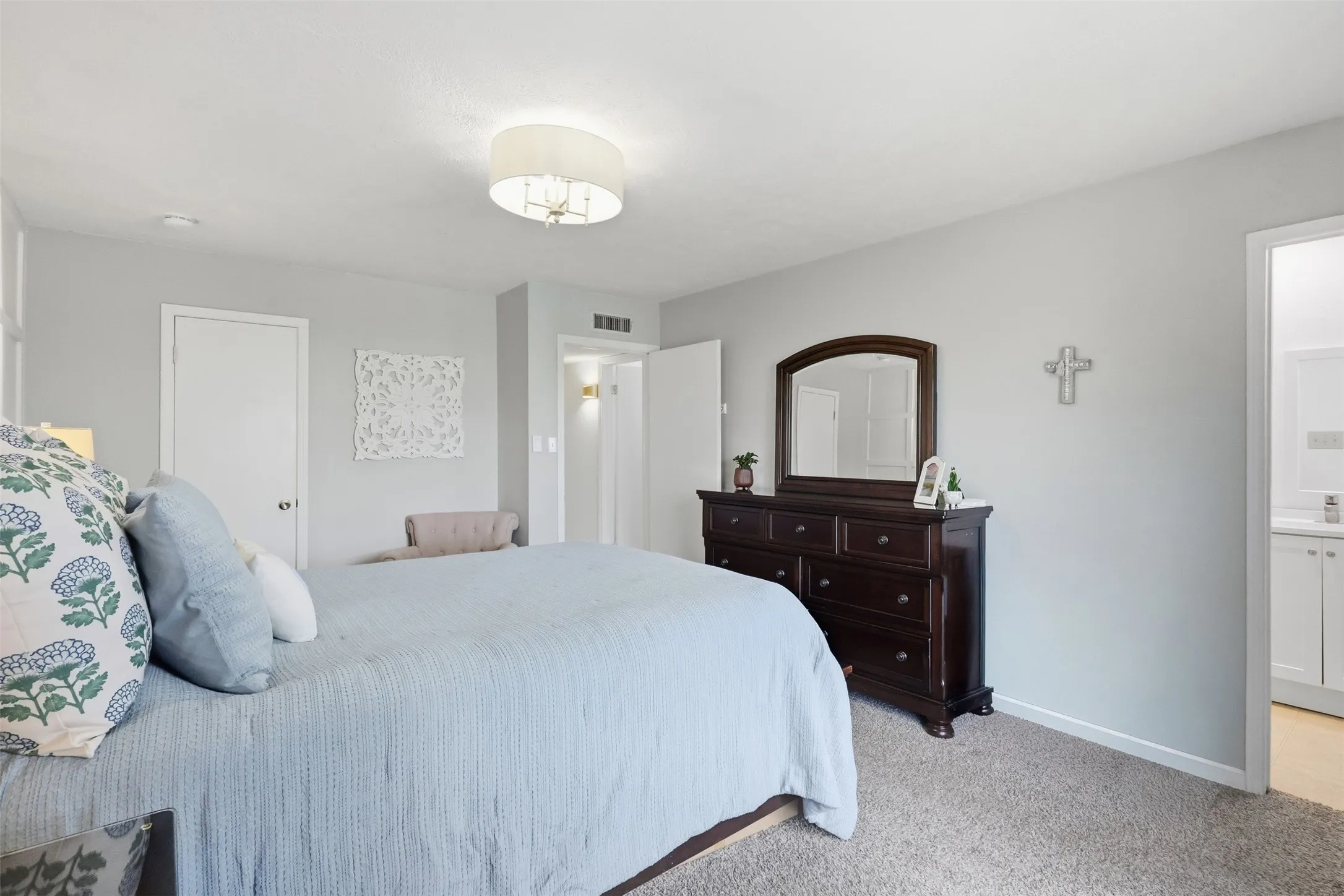 Another view of the primary bedroom highlighting the spacious layout and bright, neutral feel.