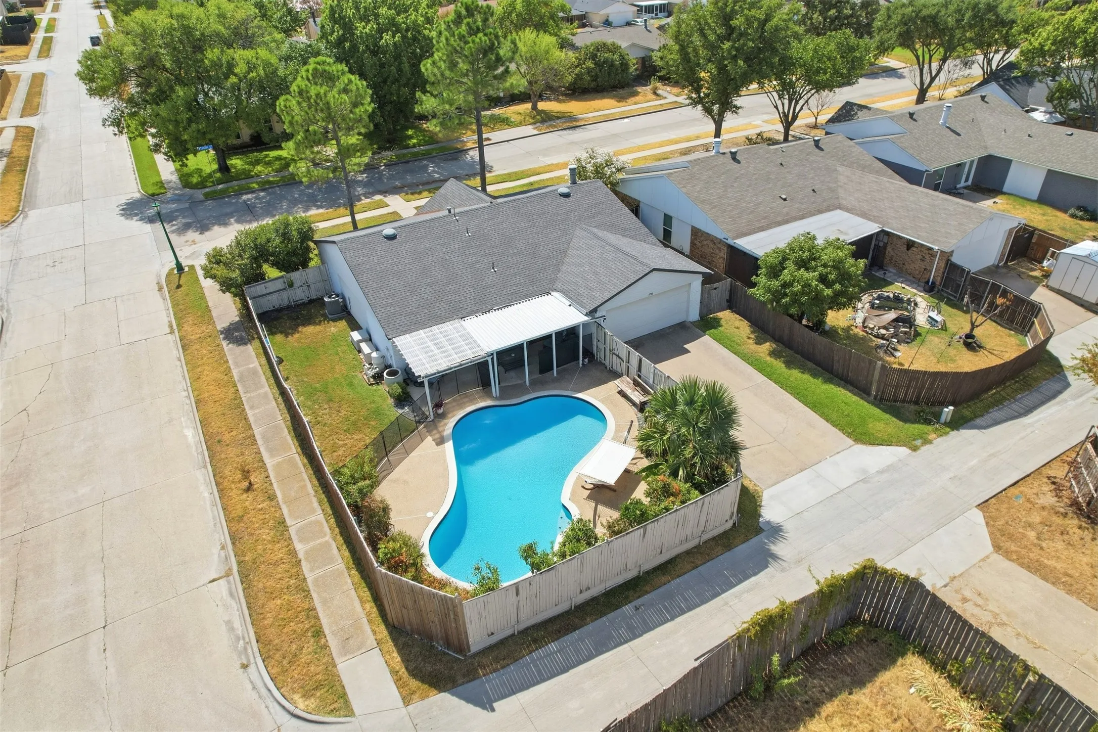 Overhead view showcasing the pool, two-car garage, corner lot, and backyard layout.