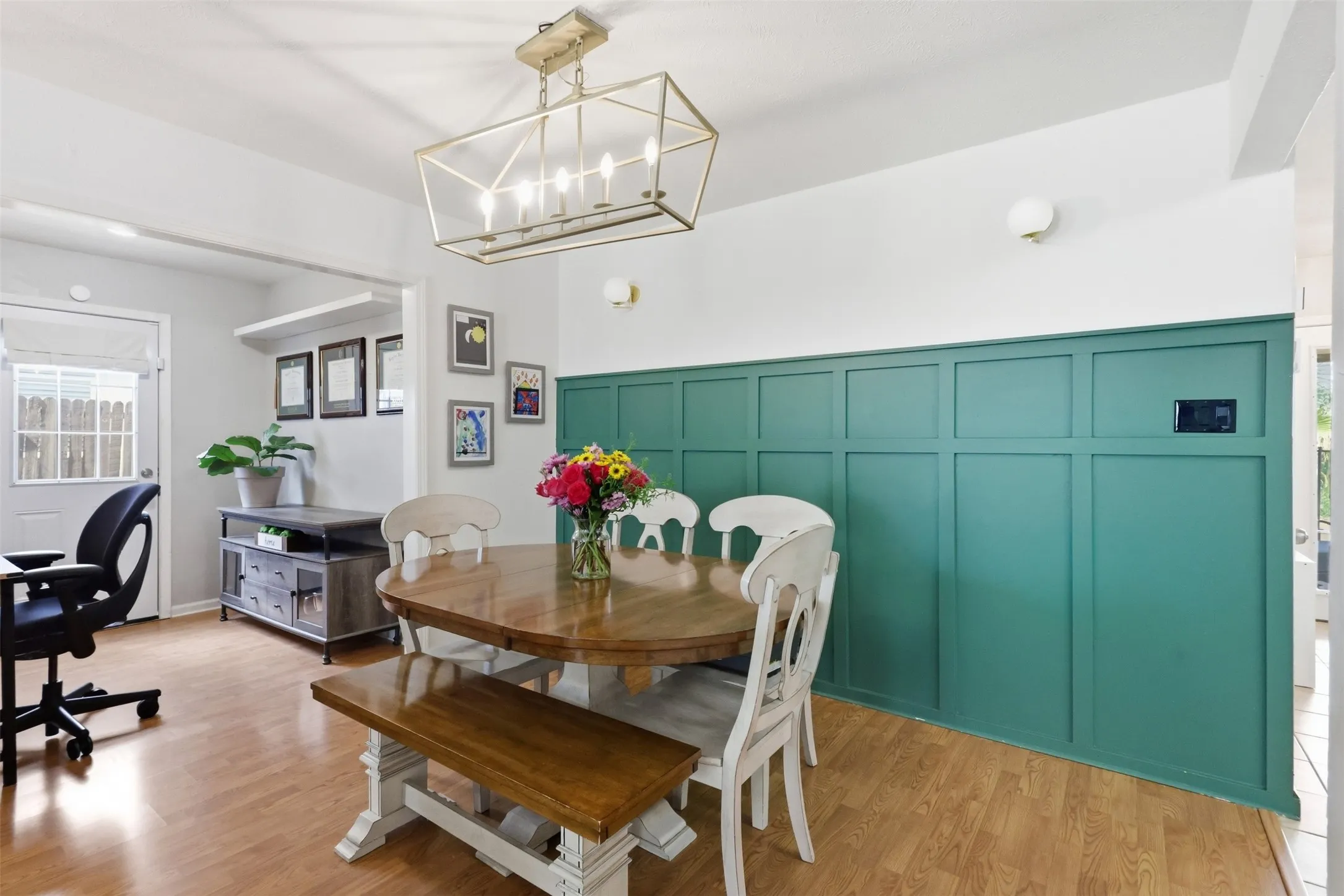 Dining space with updated lighting and a bold accent wall, plus nearby flex space ideal for an office or playroom.