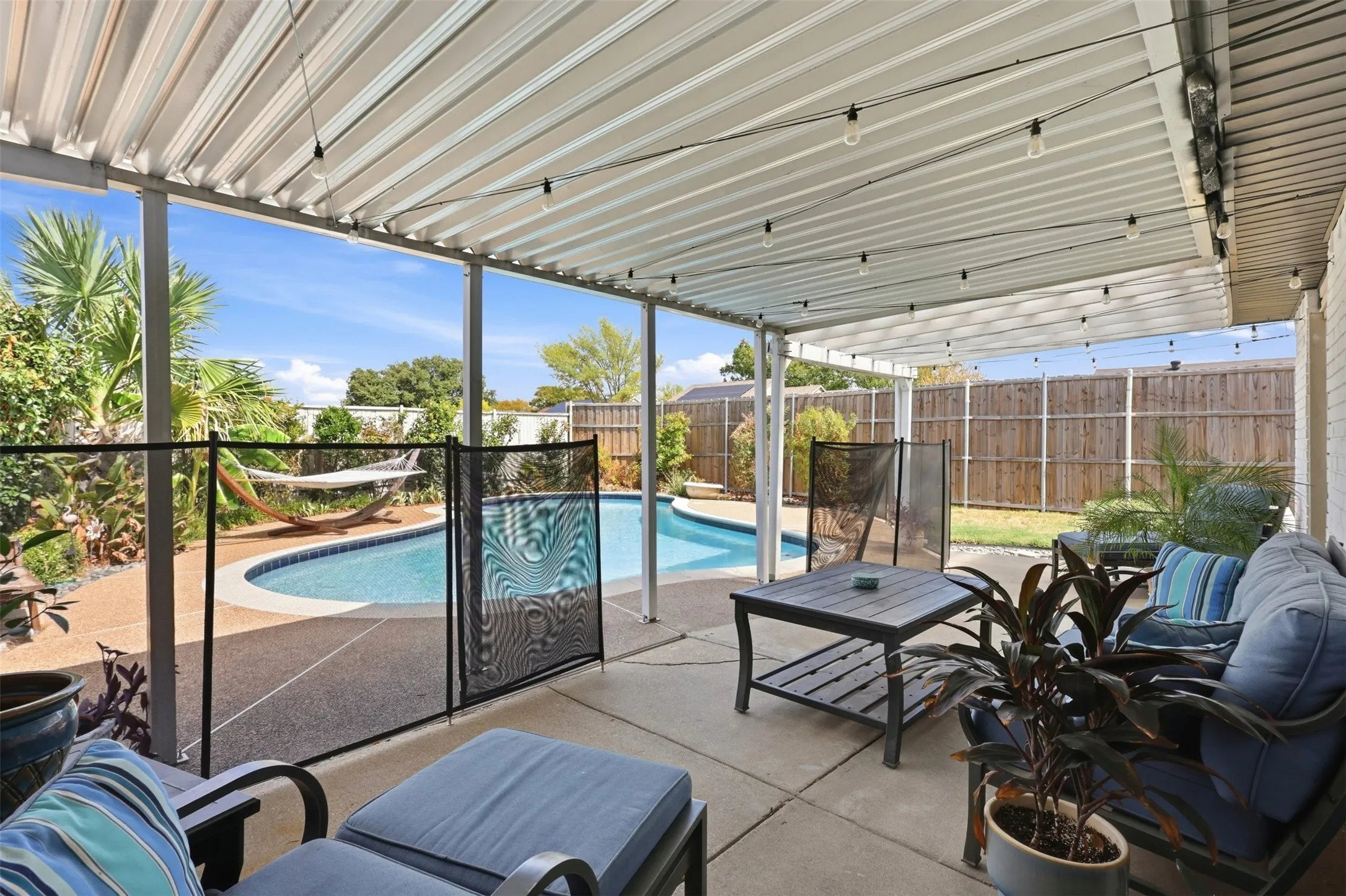 Covered patio overlooking the backyard and pool, offering a great spot to relax or entertain.