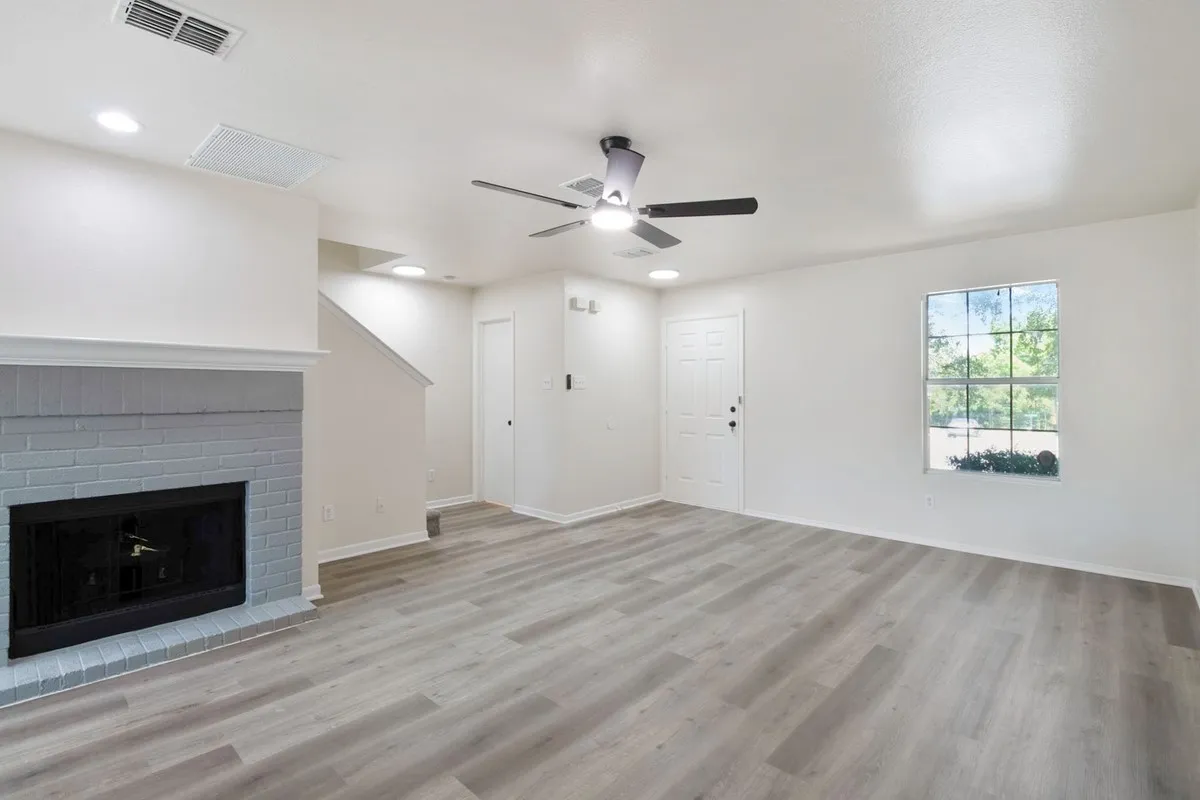 Living space featuring wood-finish flooring, a painted brick fireplace, recessed lighting, and a ceiling fan