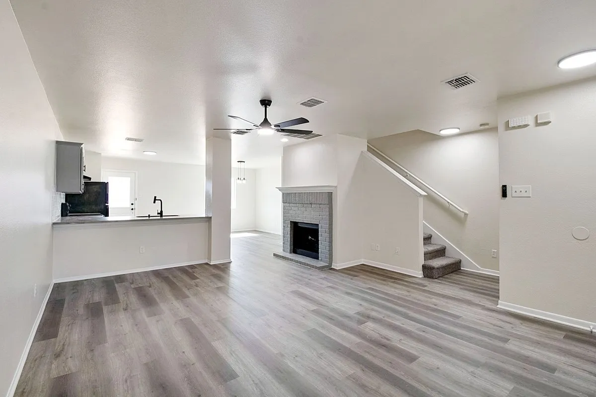 Open-concept living area featuring wood-finish flooring, a contemporary ceiling fan, and recessed lighting