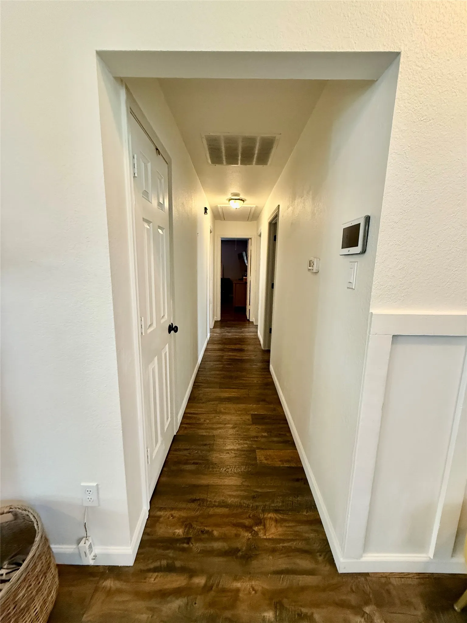 Wood-finish flooring throughout the hallway