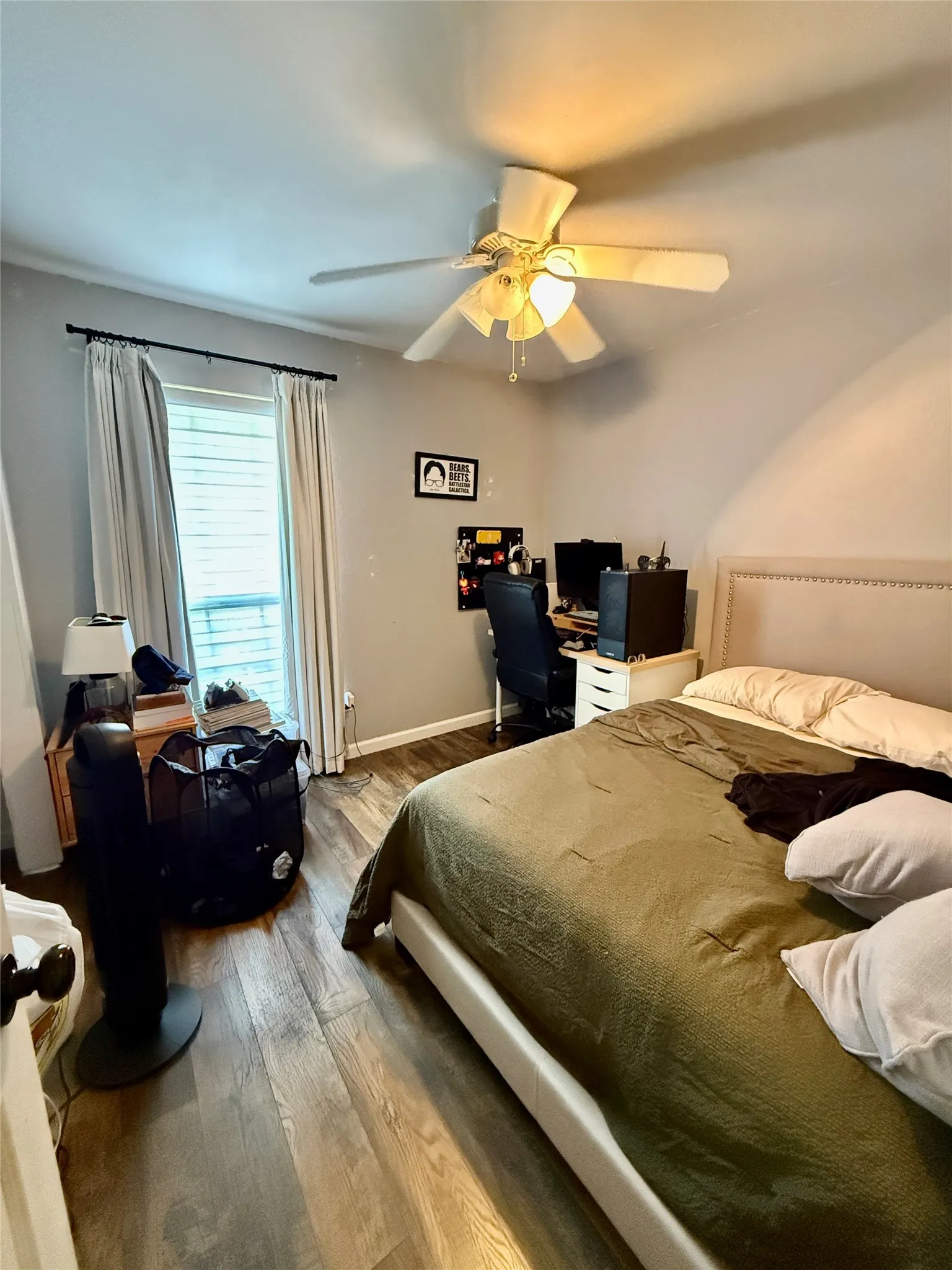 Wood-finish flooring, ceiling fan with integrated lighting, and window with horizontal blinds