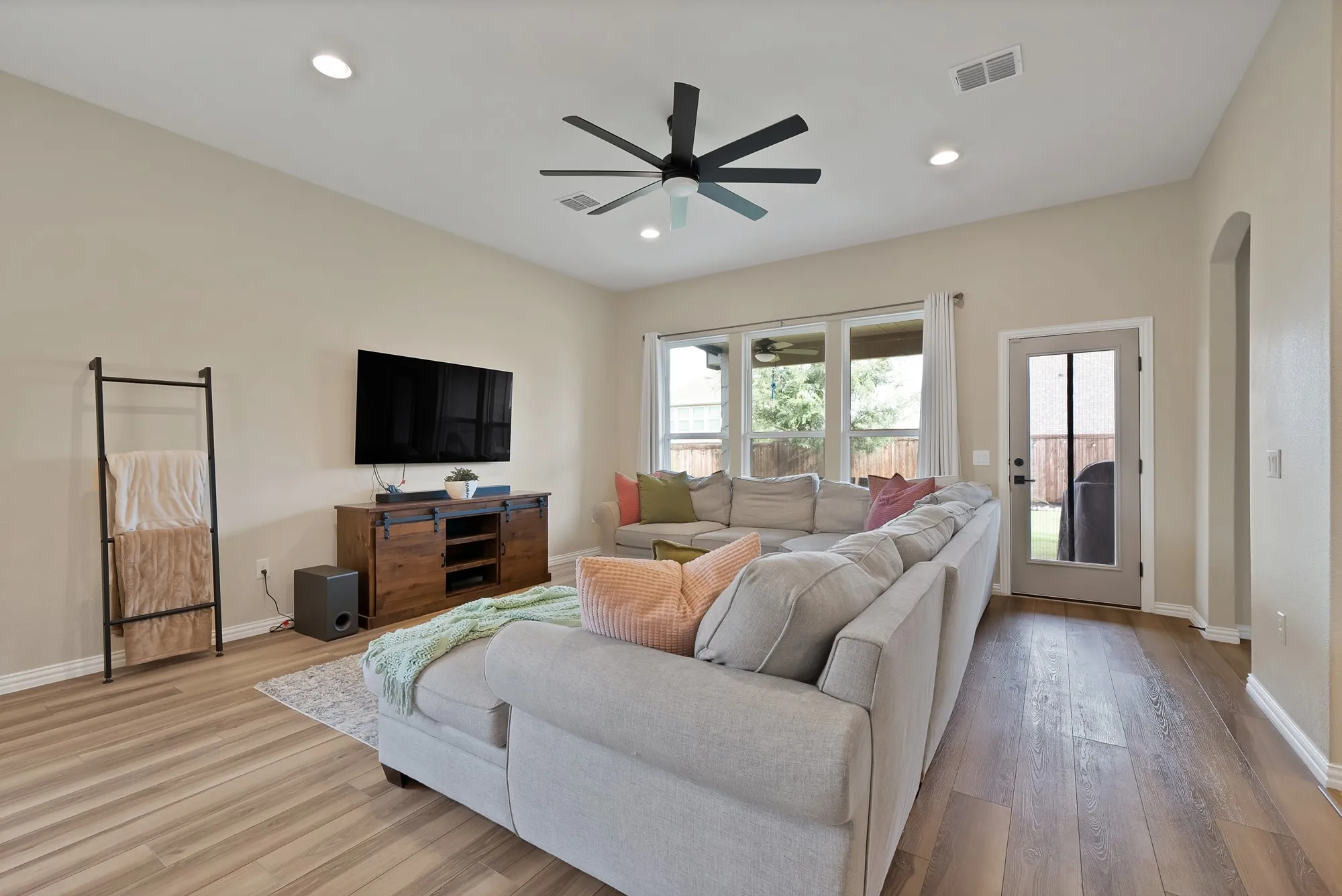 Vaulted ceiling with a ceiling fan, recessed lighting, wood-finish flooring, and a glass-paned exterior door