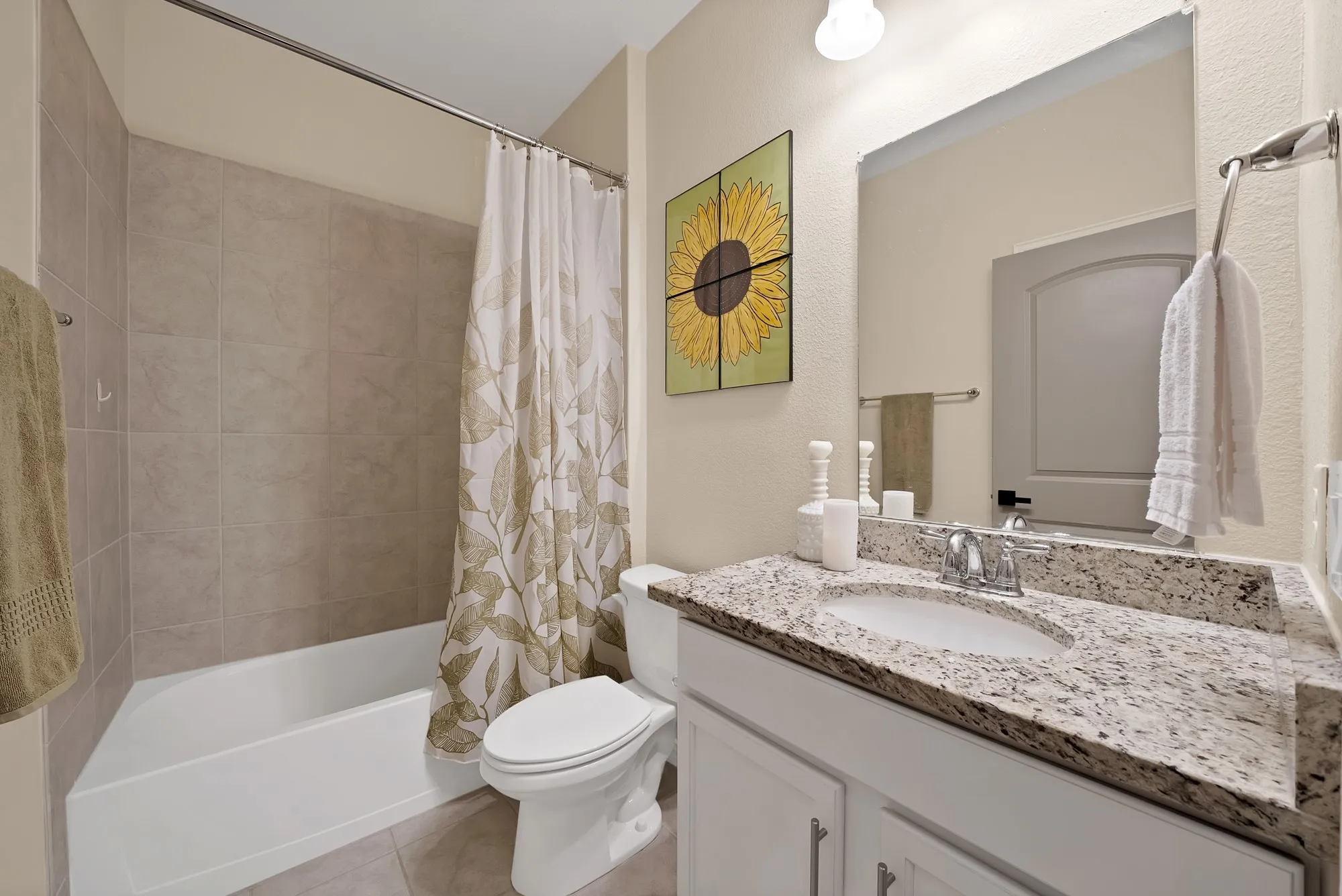 Bathtub with subway tile surround, single vanity with light-colored countertop, and a built-in toilet