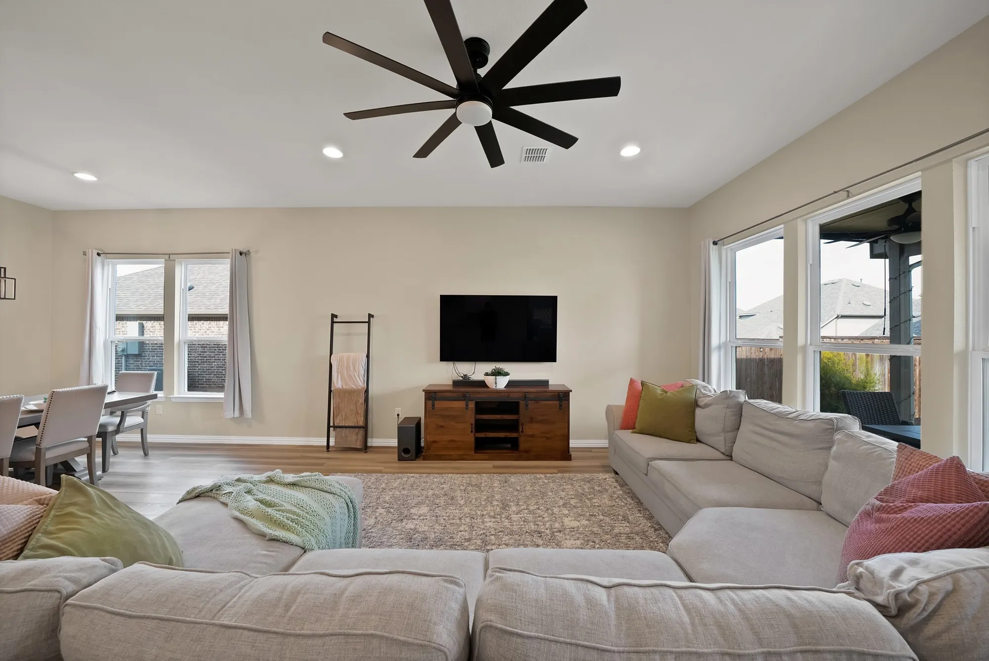 Recessed lighting, wood-finish flooring, and a contemporary ceiling fan