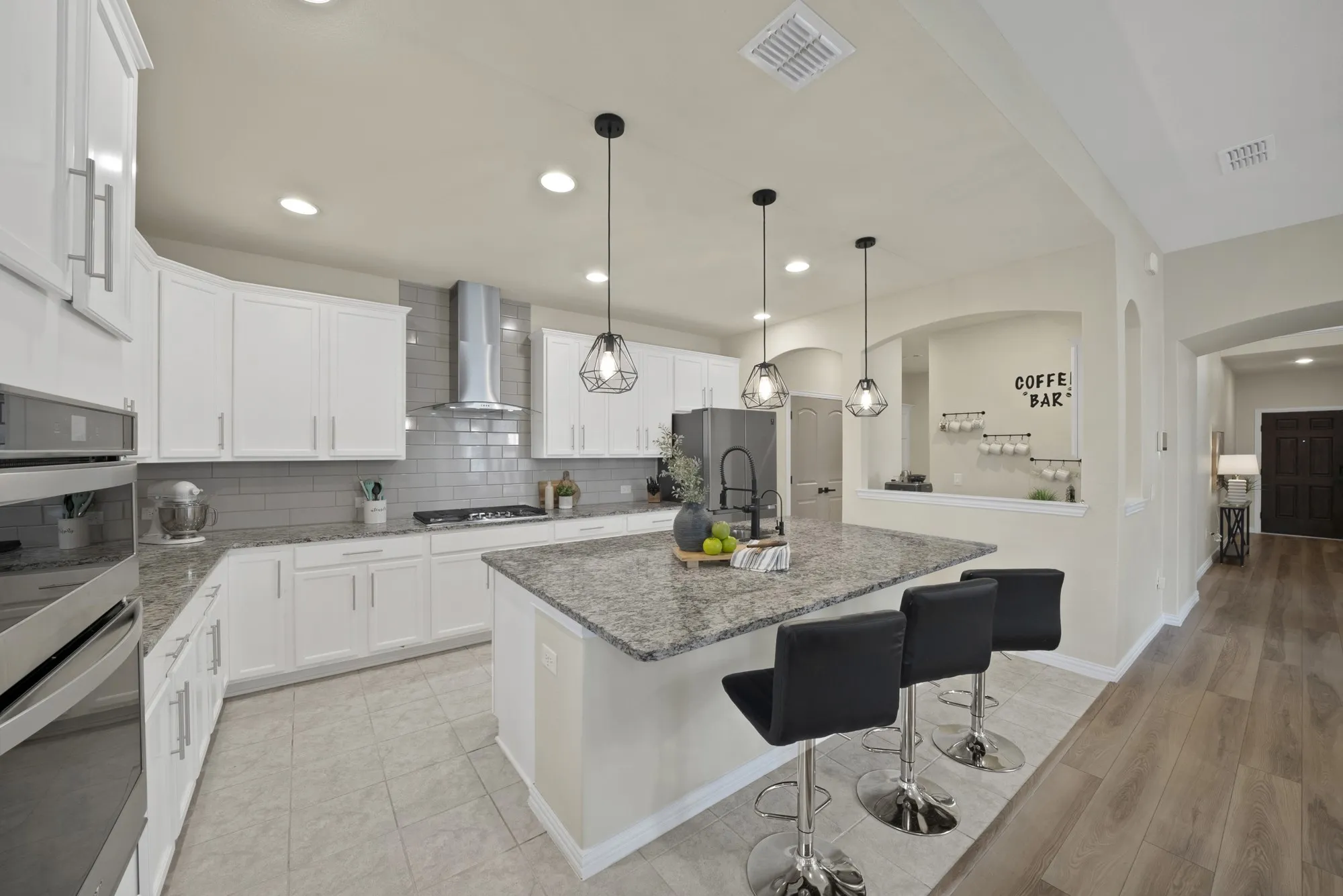 Modern kitchen featuring crisp white cabinetry, stainless steel appliances, and a gray subway tile backsplash