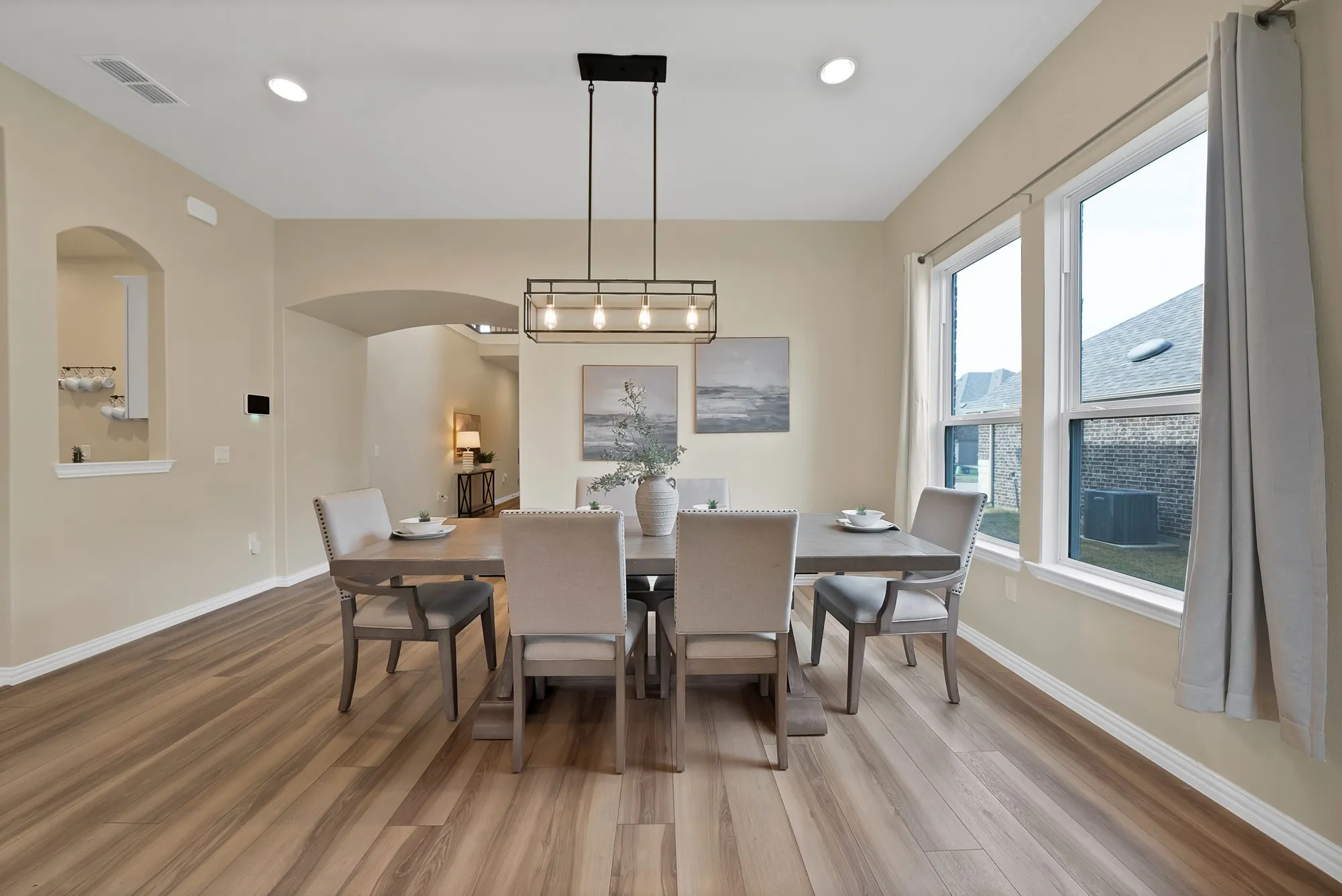 Spacious dining area featuring wood-finish flooring, recessed lighting, and a modern linear chandelier