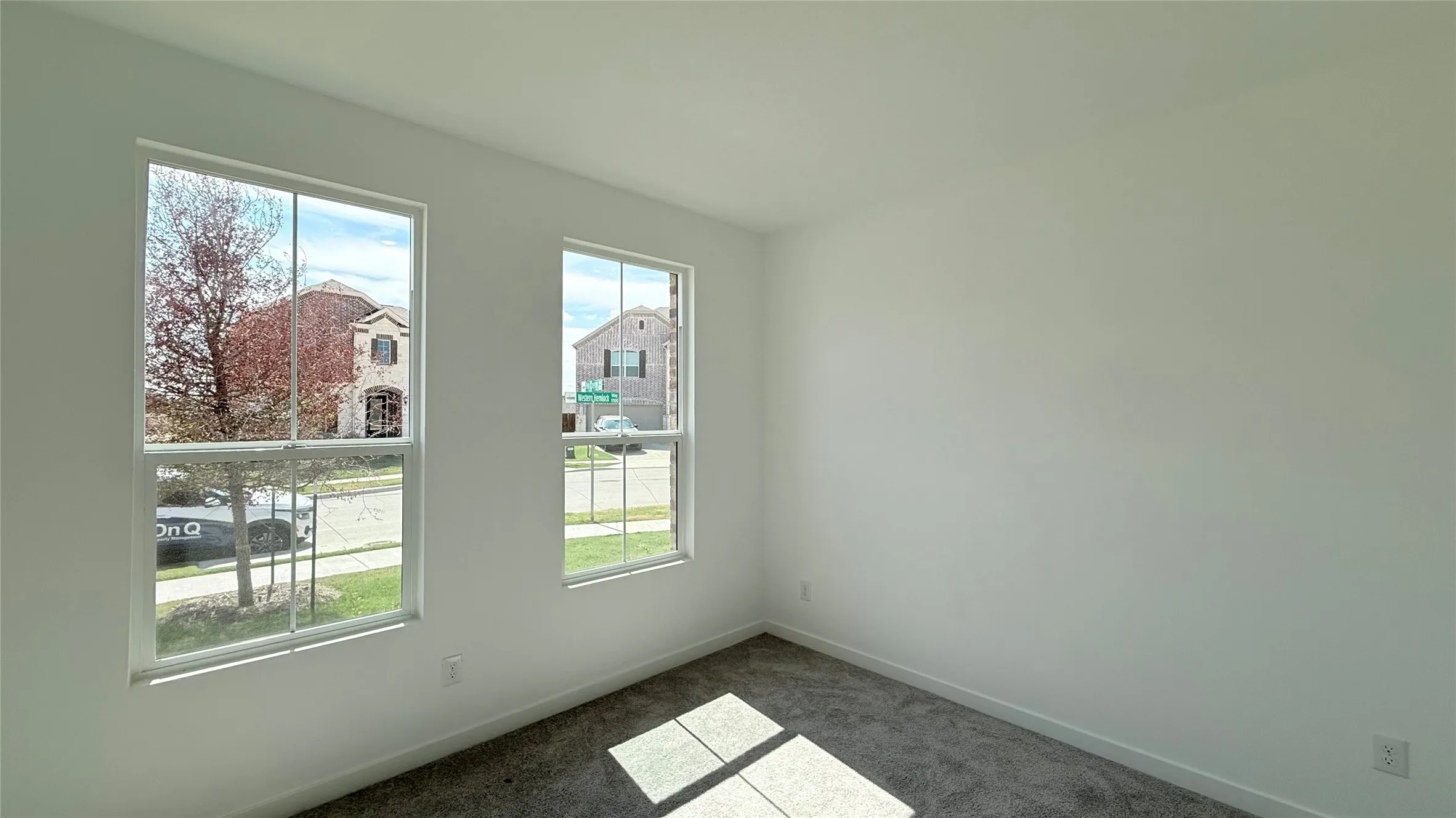Dual windows, light-toned walls, and carpet flooring