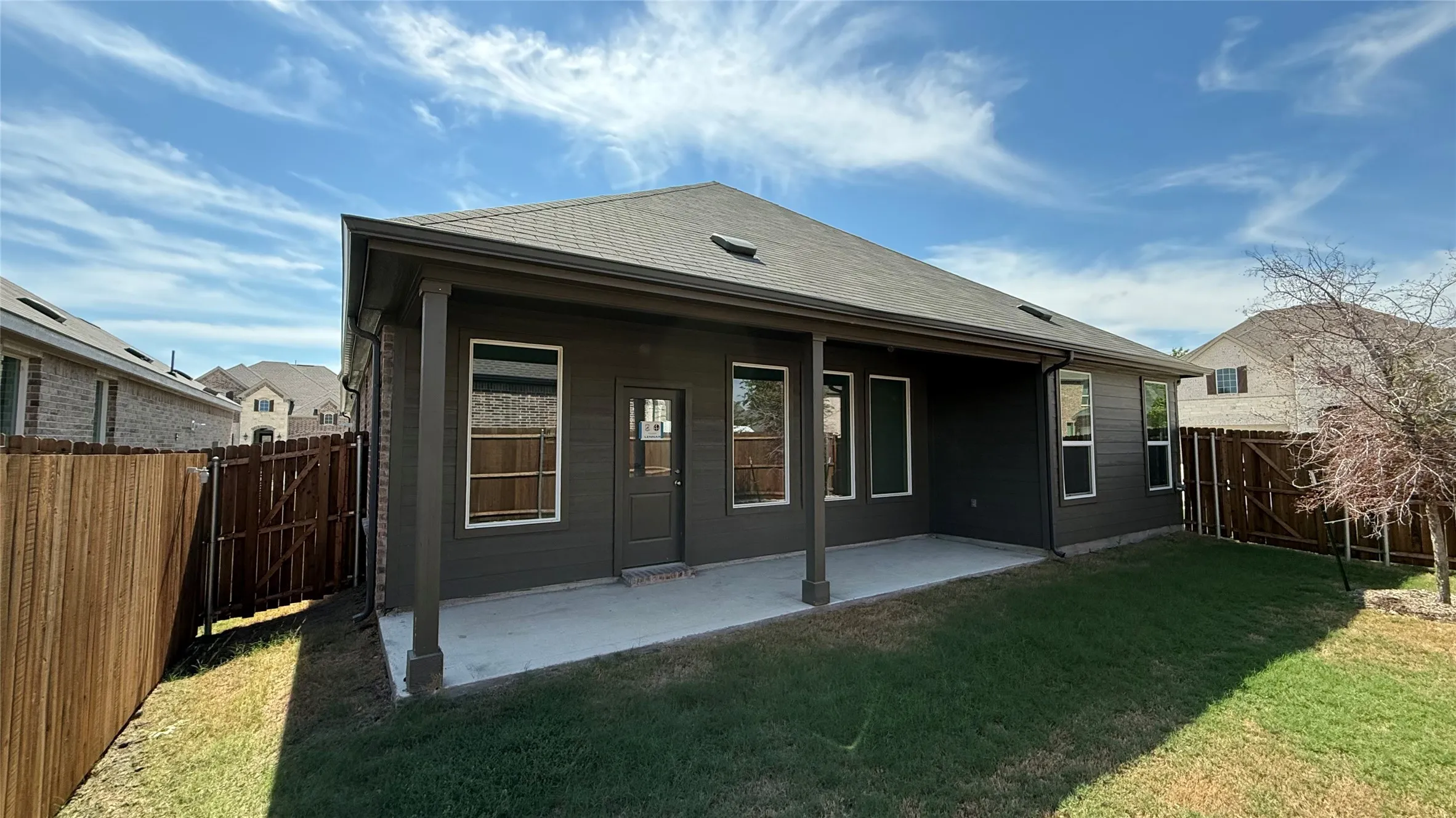 Covered concrete patio with column supports, siding exterior, and wood fencing