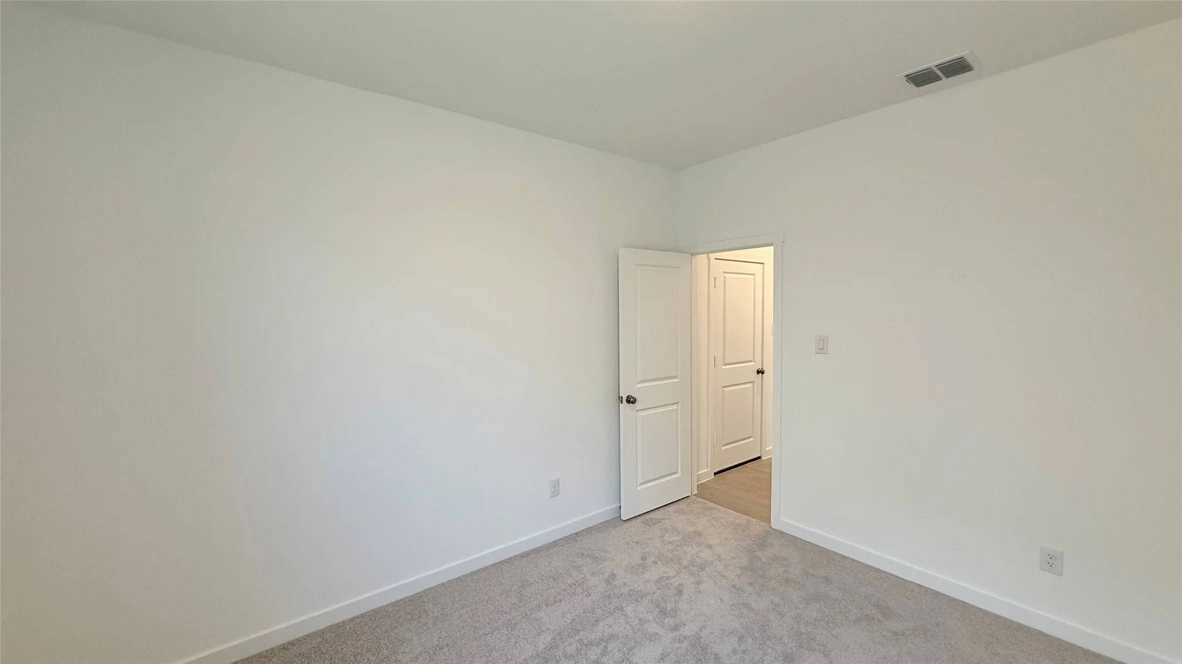 Plush carpet flooring, white painted walls, and white trim molding