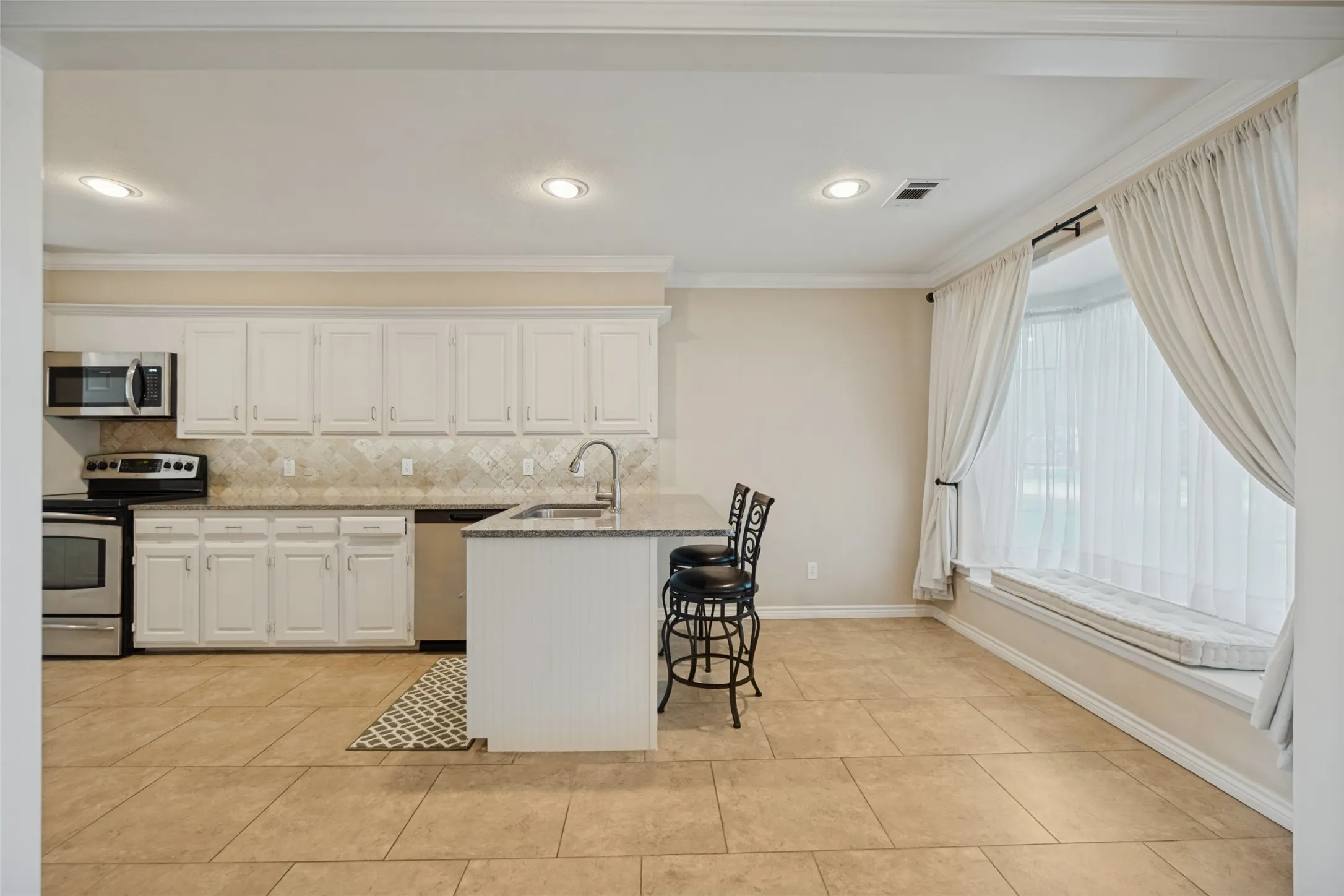 Pretty kitchen breakfast nook with window seat and breakfast bar.