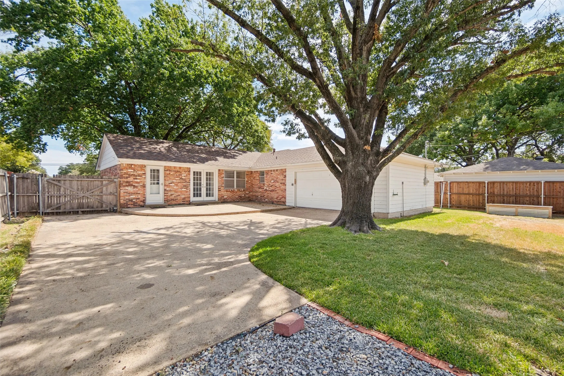 Fenced yard with mature trees.