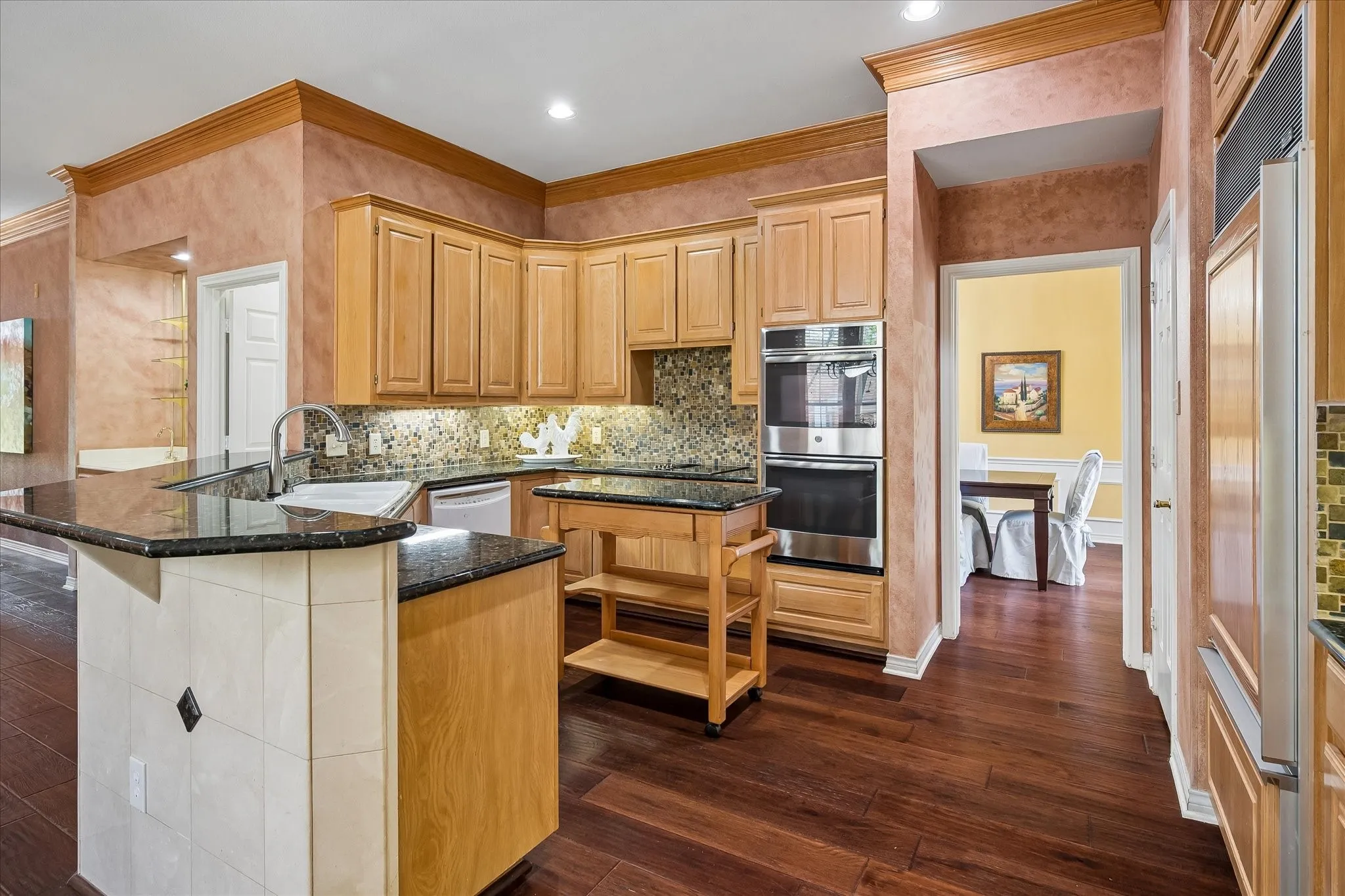 Hearty Hickory Floors continue through the kitchen.  Granite counters and movable island allow for a variety of cooking and baking options