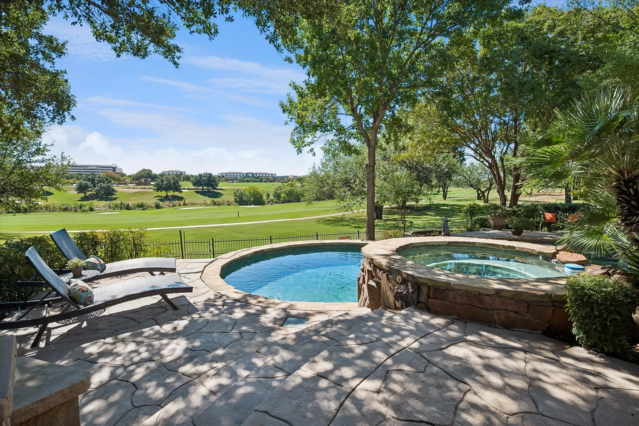 Additional patio surrounded by mature trees, and a golf course and creek backdrop