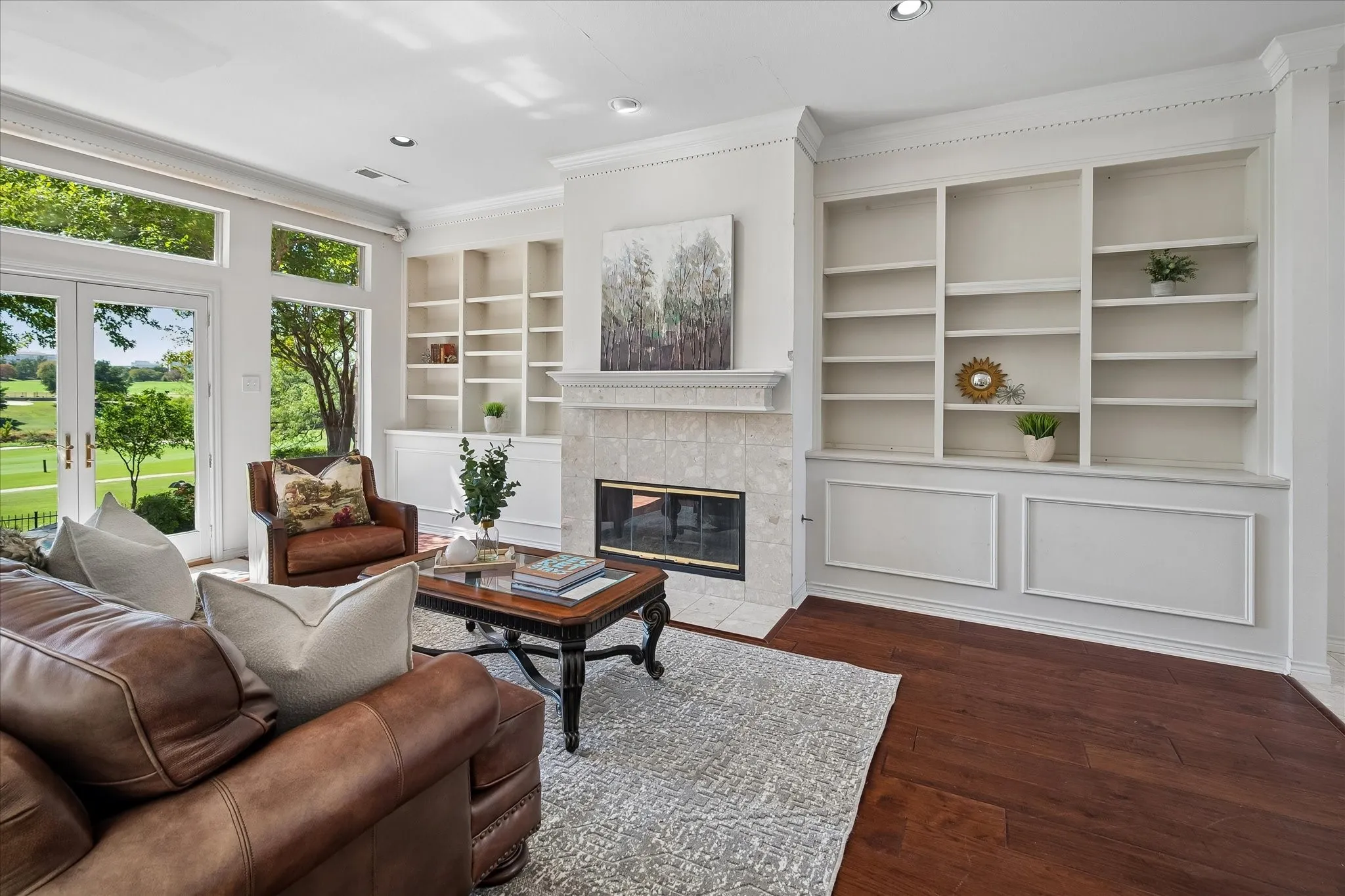 Built-in shelving, Hickory wood flooring, recessed lighting, and a fireplace with tile surround